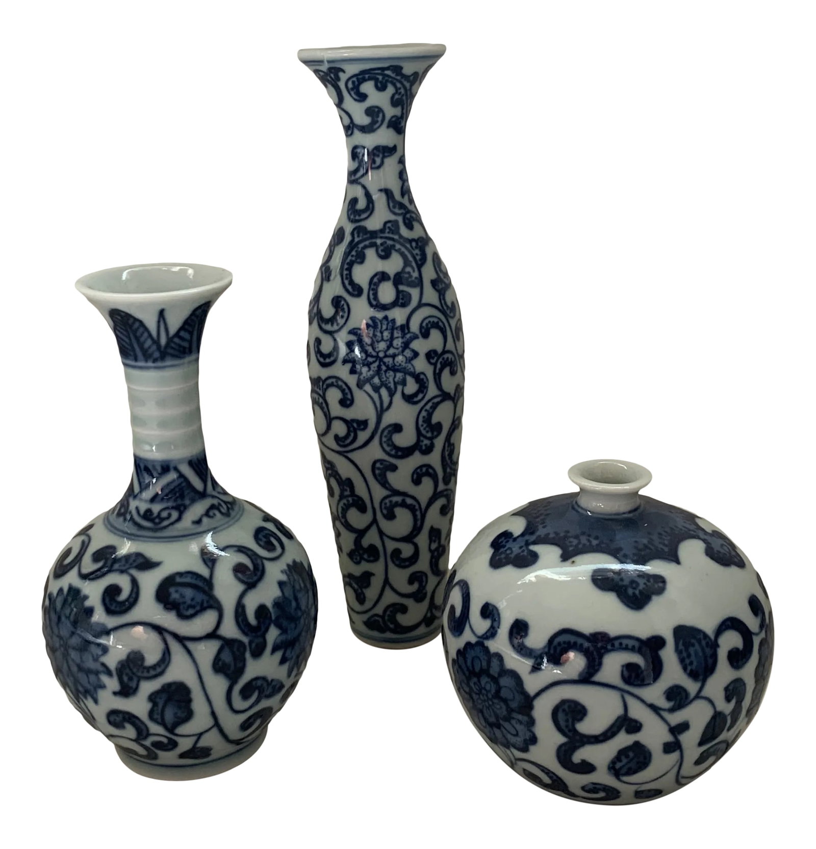 Blue & White Porcelain Chinoiserie Vases - Set of 3: A curated set of three small Chinese vases with floral blue-and-white transfer pattern. Artist stamp on underside. Measurement is for the tallest vase. Shortest vase measures 3"H x 3" x 3". Condition: