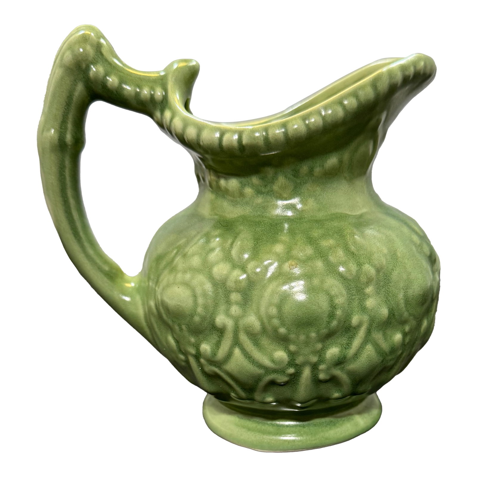 Vintage Mid Century Modern Camark Pottery Sage Green Ornate Pitcher 6": The Vintage Camark Pottery Sage Green Ornate Creamer Pitcher is a collectible piece made in the United States using the pottery production technique. It features a unique baroque style design in a bea