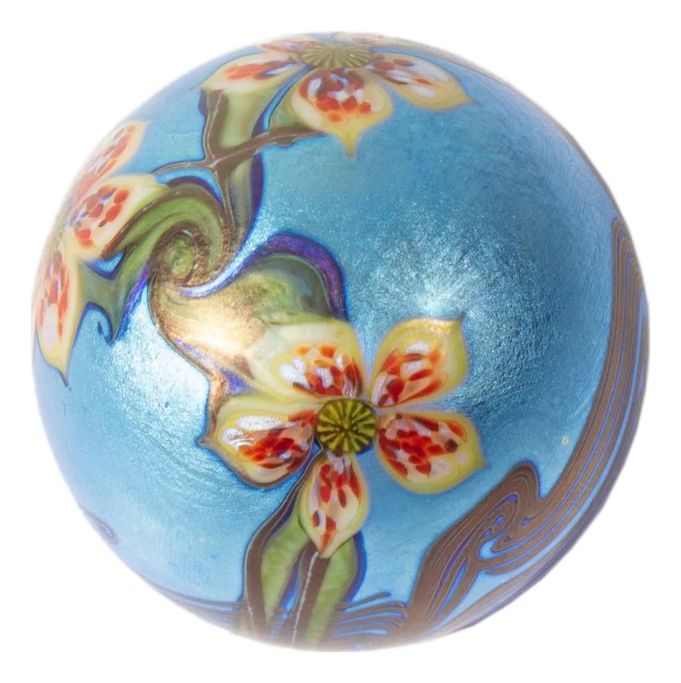 Orient and Flume 1977 Iridescent Art Glass Paperweight: A 1977 iridescent art glass paperweight by Orient and Flume. This spherical paperweight features orange flowers against a light blue background. Marked "Orient & Flume M 58 S 1977" to underside. Orien