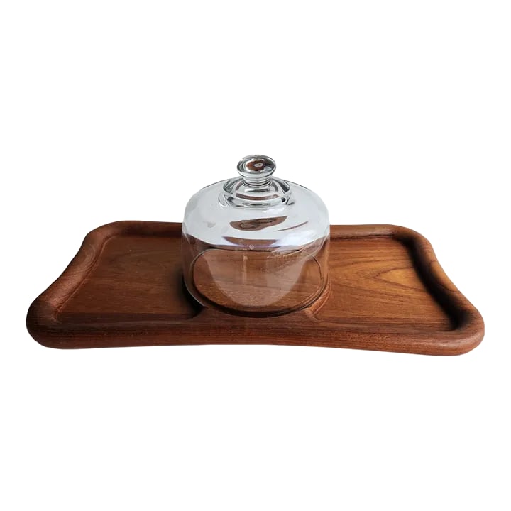 1970s Teak Wood Bone Shaped Cheese Board With Glass Cloche, 2 Pieces: Offered is a fun teak wood bone or ribbon shaped cheese or charcuterie board with a glass dome cloche. When we say bone, we are referring to a dog biscuit shape. Great for entertaining, perfect for