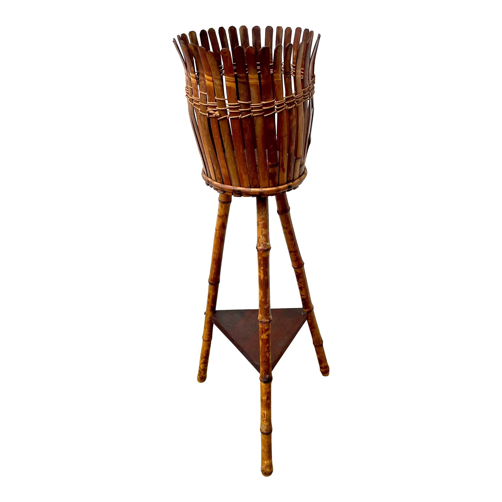 Antique Burnt Bamboo Plant Stand: This 1930's plant stand is comprised of three burnt bamboo legs with holding a bamboo casement for a planter and a wood shelf below. The basket is 8" diameter Condition: Alterations: Original Conditio
