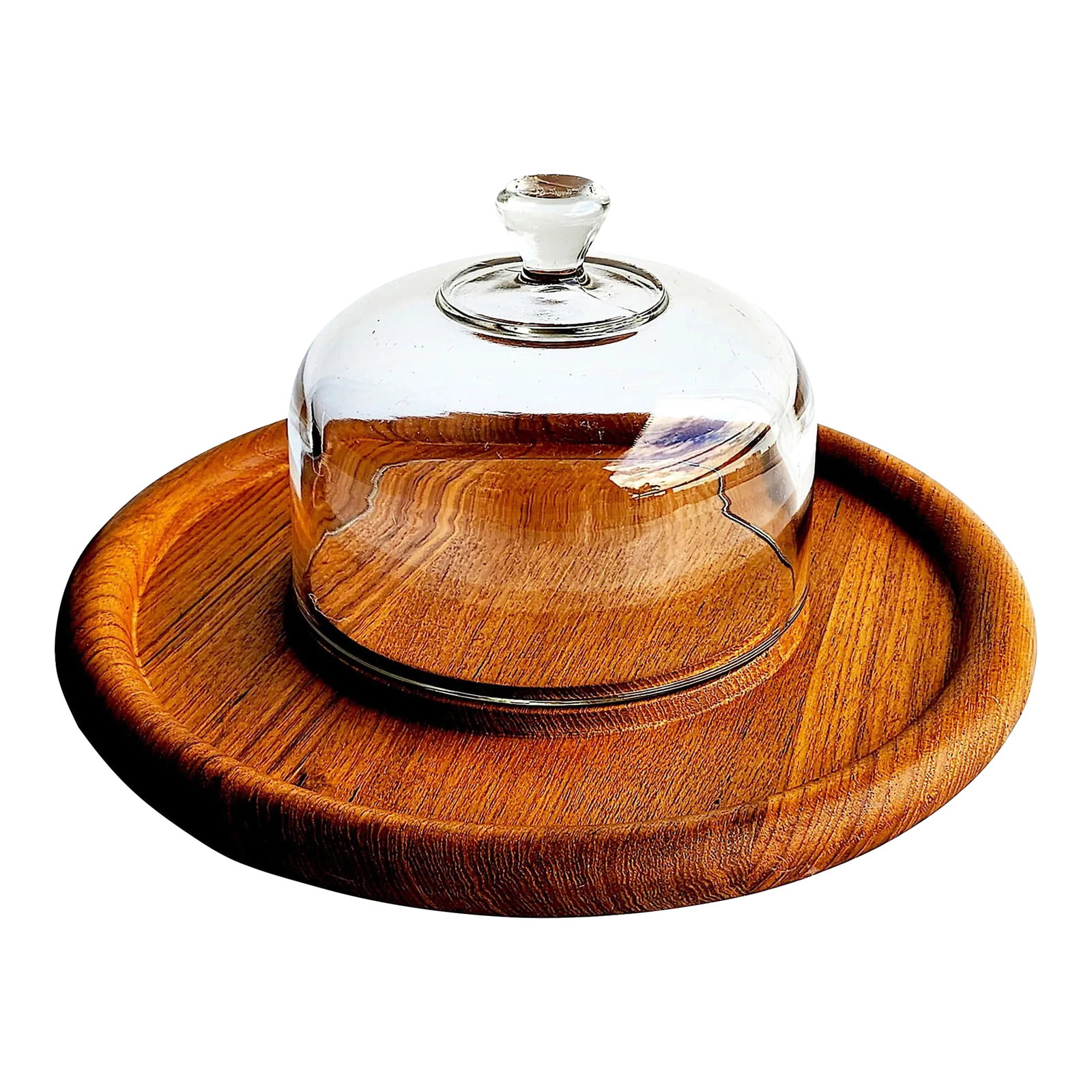 1970s Teak Wood Cheese Board With Glass Dome Cloche, 2 Piece Set: Offered is a thick teak wood round shaped cheese or charcuterie board with a glass dome cloche made by Goodwood. It has a chunky rolled edge which contains the crumb moat rim. The raised surface has
