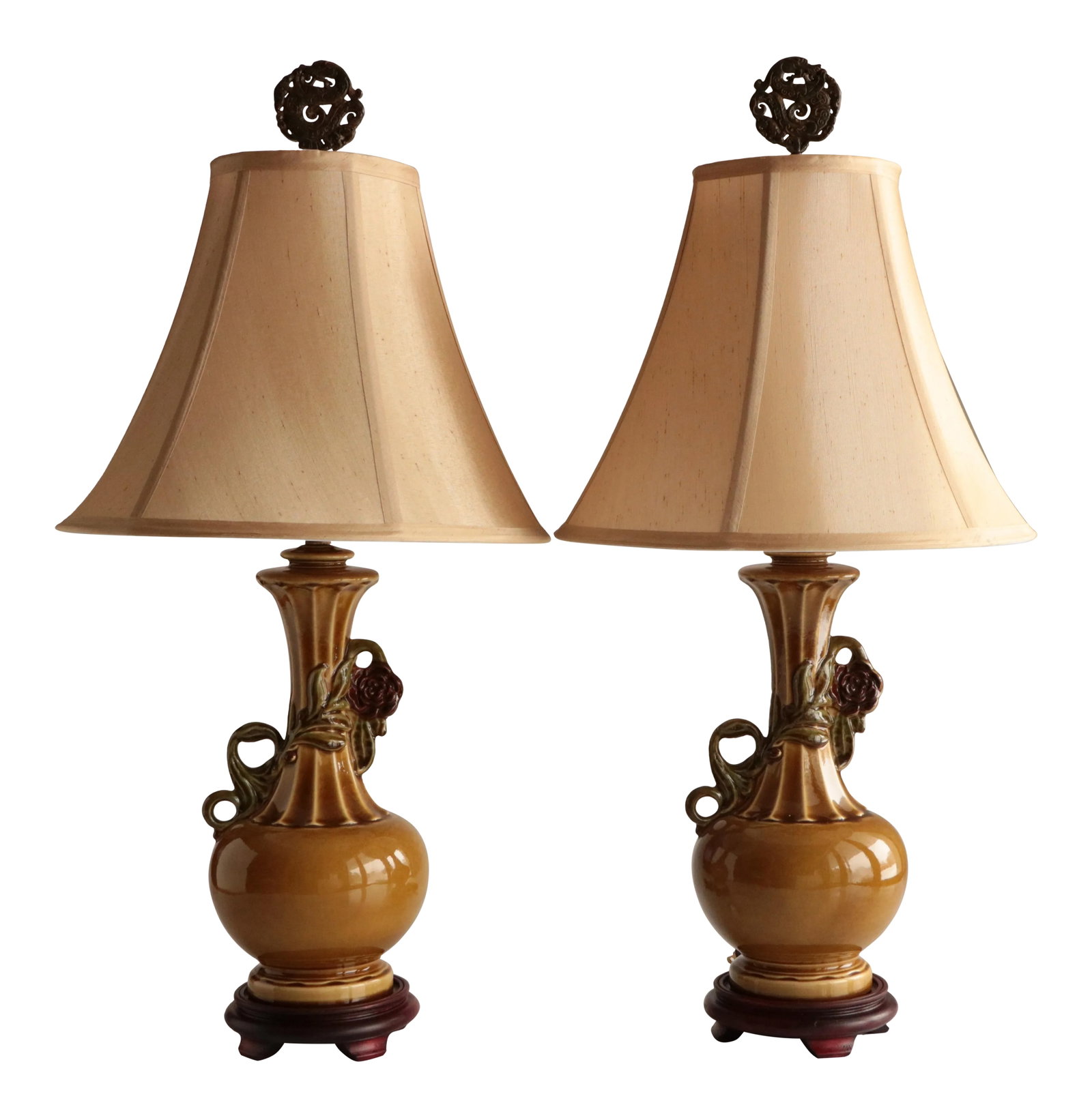 1940s Chinoiserie Table Lamps - a Pair: Pair of vintage Asian-style glazed ceramic table lamps on footed, mahogany-tone bases. Globular form with a ribbed neck and scrolled floral vines set against rich, dark gold vessels. Standard three-wa