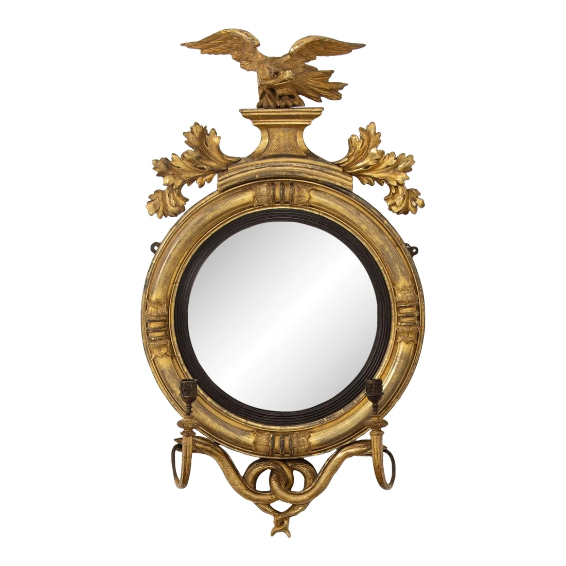 19th Century English Regency Convex Mirror in Original Giltwood: A fine Regency original giltwood mirror with convex mirror plate. The frame features carved lotus flower terminals meeting at the four compass points. The mirror is topped by a cresting of an eagle on
