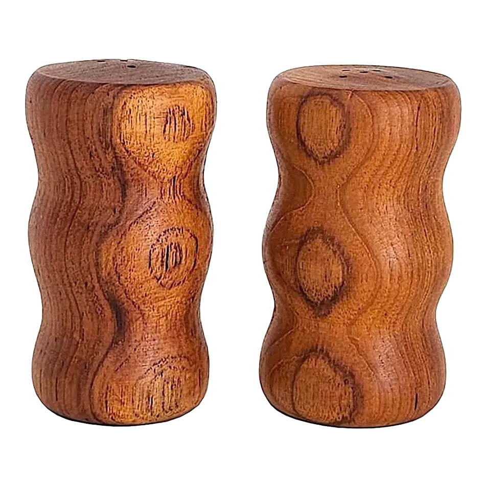 1970s Teak Wood Curvy Salt and Pepper Shakers, a Pair: Offered is a set of groovy curvy teak wood salt and pepper shakers. The curves are part of the design, but have an ergonomic benefit as they are fun to hold, and will keep enthusiastic seasoning
