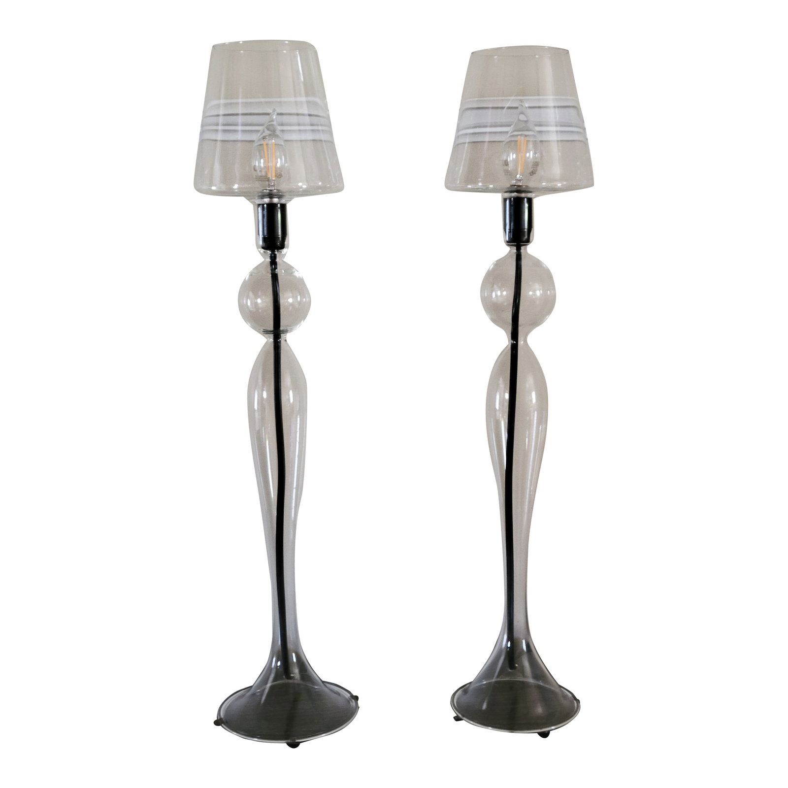 Les Heritiers Hand-Blown Glass Lamps - a Pair: This custom pair of glass lamps are hand blown from a simple glass tube by a master craftsman, making each piece truly unique. Condition: Alterations: Original Condition Unaltered Imperfections: Some