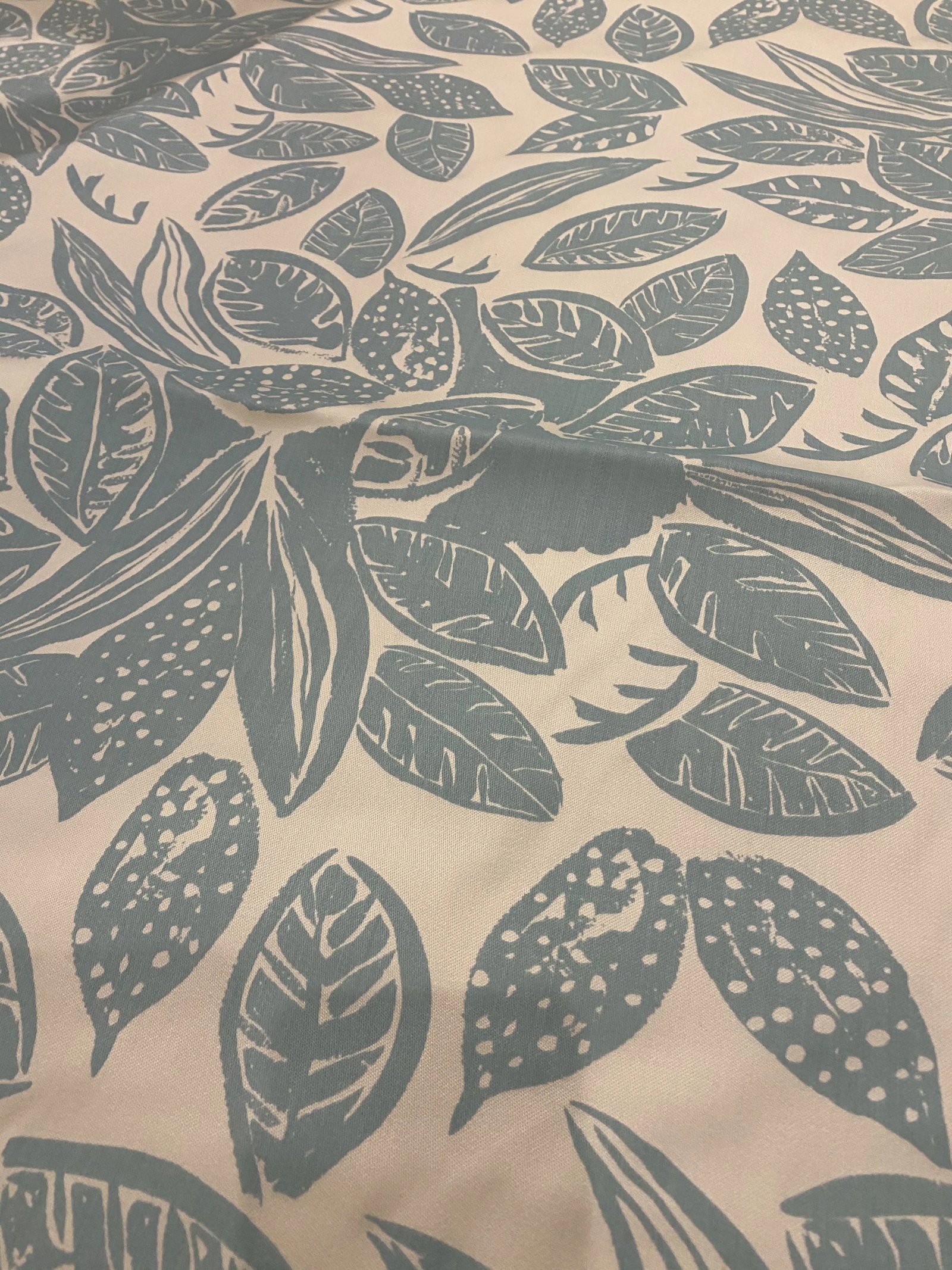 Marimekko Viikuna Tropical Leaves Fabric Remnant: China Seas' 54" wide cotton / linen blend fabric features a modern tropical leave print in aqua on a cream ground. Designed by Fujiwo Ishimoto Marimekko. Remnant is 54" wide x 64" long. Condition: