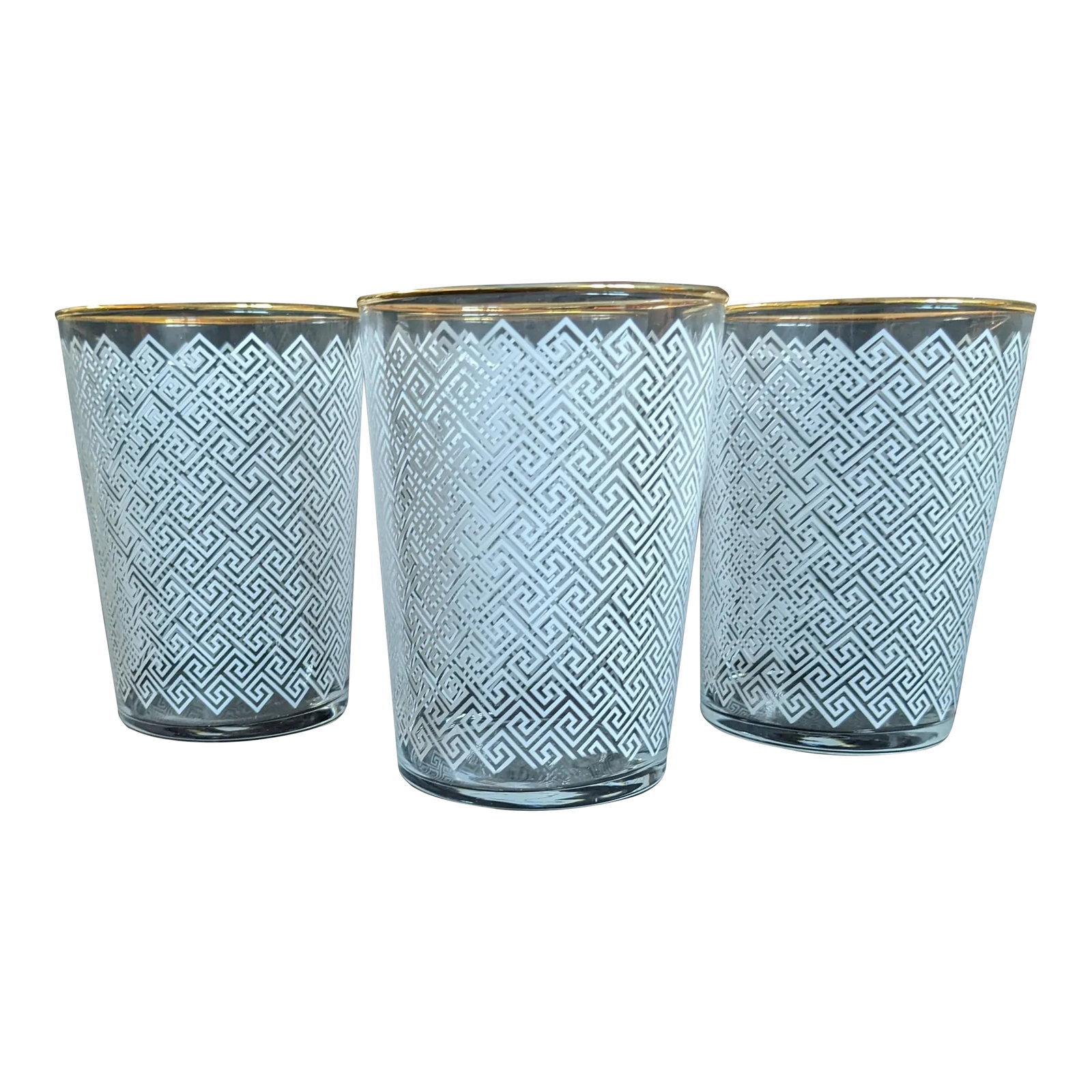 1970s Inspired Regency Mid-Century Modern White Greek Key and Gold Rimmed Drinking Glassware Set - S: This set of four (4) drinking glasses depicts a white greek-key printed motif and a gold rim. Recently manufactured with a nod to the 1940s or 1970s. Holds about 17 fluid ounces, this glass would be p