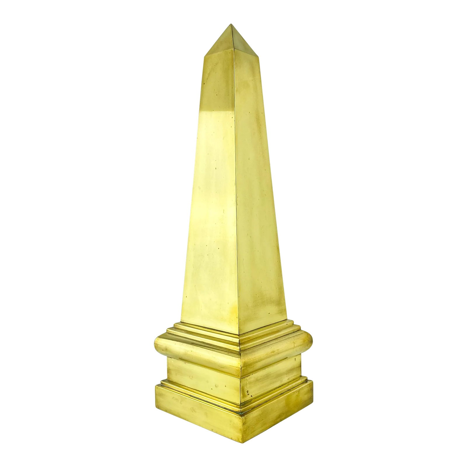 Vintage Large Brass Obelisk: Vintage circa 1970s large brass obelisk figure or sculpture. Made by a single sheet of brass and polished finish. Hollow interior with felt feet on underside. Condition: Alterations: Original