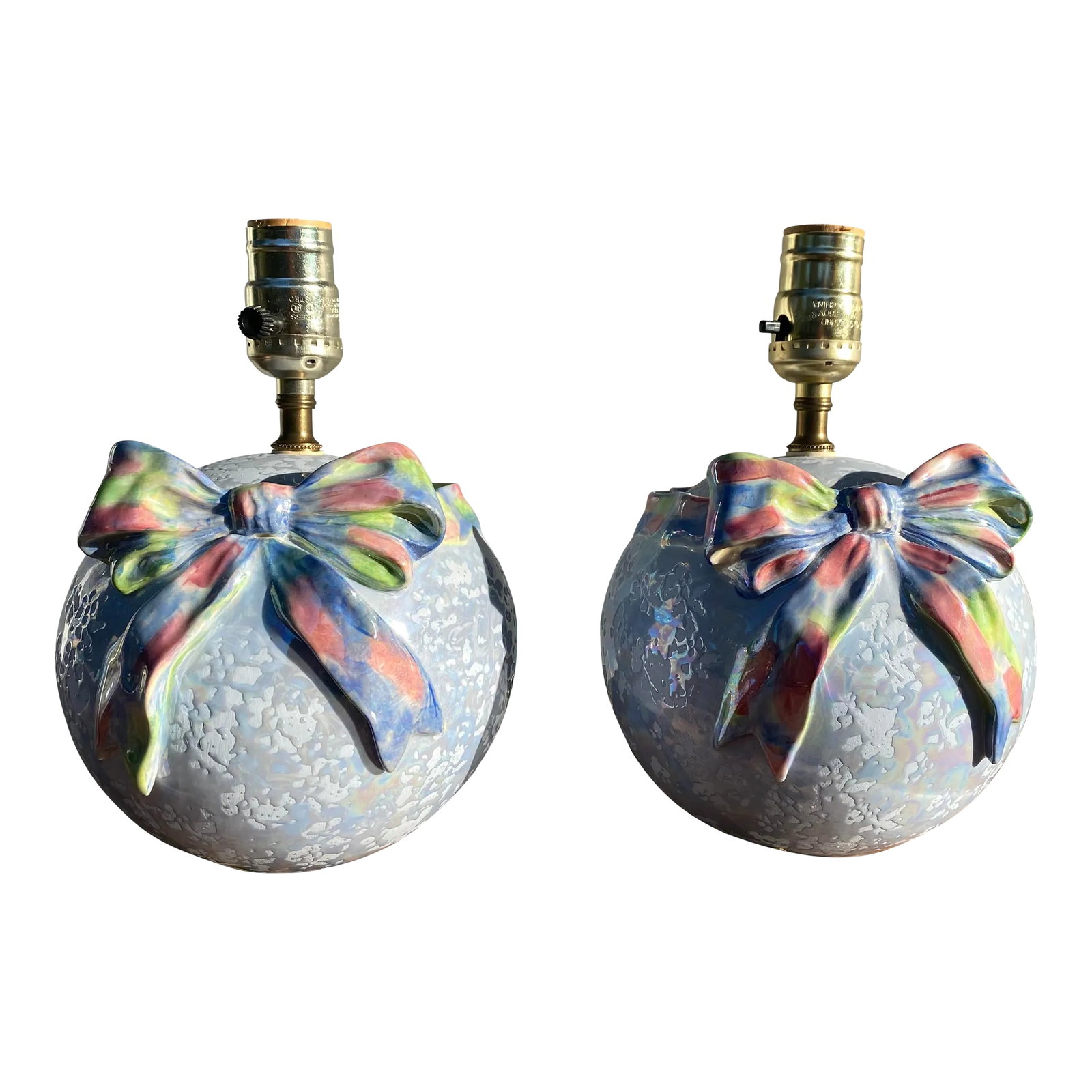 2002 Ceramic Ribbon and Bow Boudoir Lamps- a Pair: A wonderful pair of petite nightstand / boudoir lamps with a very late 1980s early 1990's feel. The glaze on the main body of each lamp is a matte blue with a glossy mottled iridescent texture over it