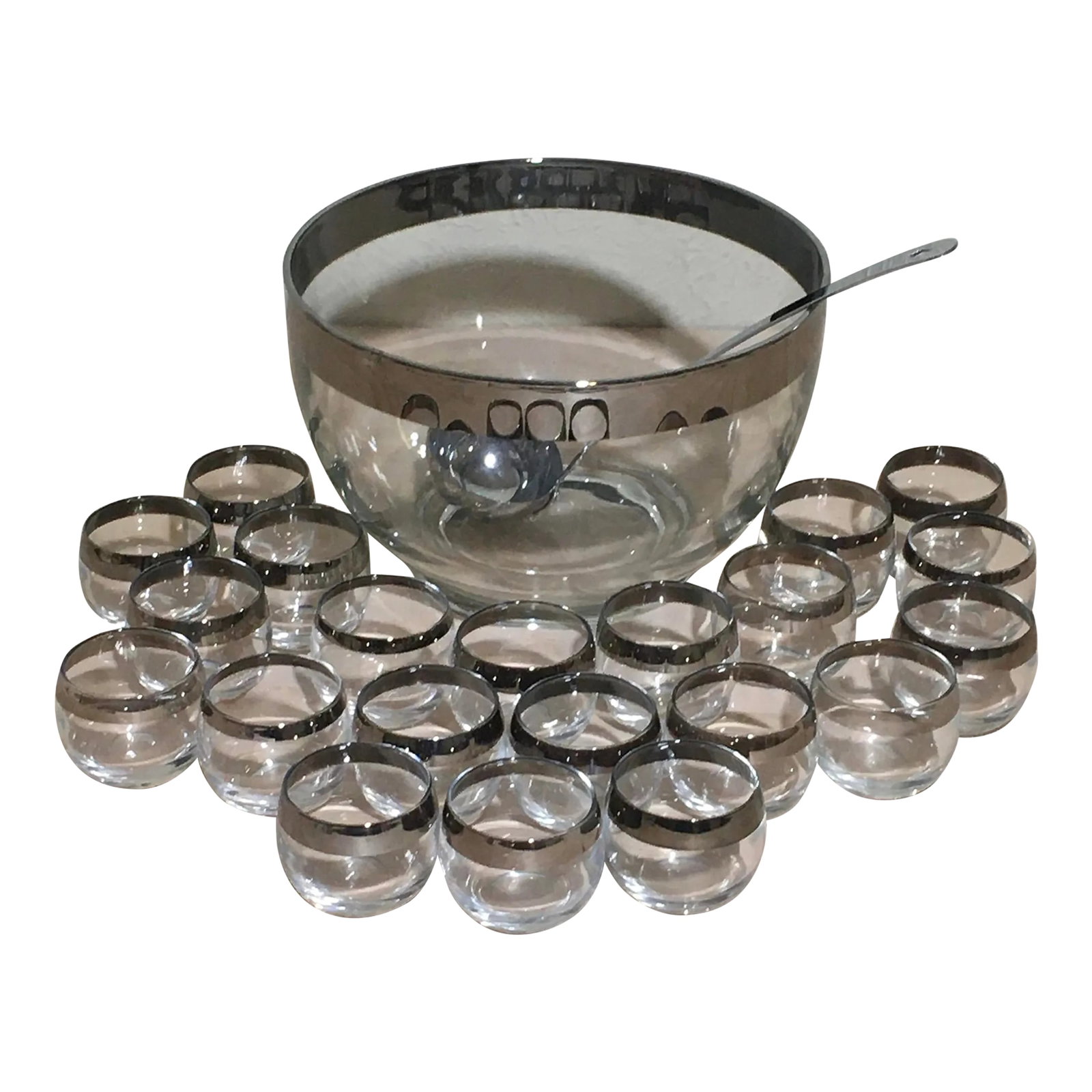 Mid Century Modern Dorothy Thorpe Style Silver Rim Roly Poly Punch Bowl Set- 23 Pieces: A mid twentieth century glass punch bowl set with silver rims. In the manner of Dorothy Thorpe. Large punch bowl with 21 small roly poly type glasses and a metal ladle. Width of the silver rims