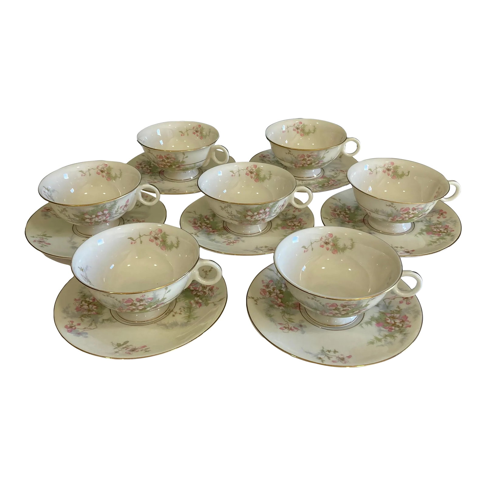 Mid-Century Theodore Haviland Apple Blossom Tea Cup & Saucer Set- 14 Pieces: A lovely set of seven Haviland NY "Apple Blossom" teacups and saucers featuring delicate floral blossoms and refined gold trim. The soft pastel floral pattern and classic cup shape make this an