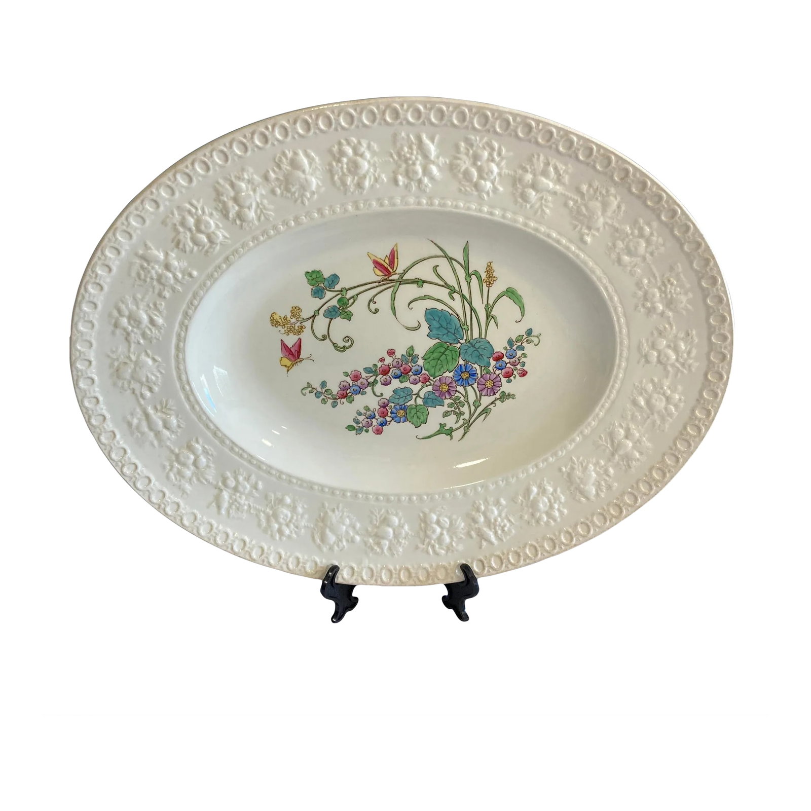 Wedgwood Embossed Floral Oval Platter - English Vintage: Elegant and timeless, this Wedgwood oval serving platter showcases a delicate hand-painted floral bouquet with butterflies and trailing wildflowers against a crisp white ground. The wide rim features 