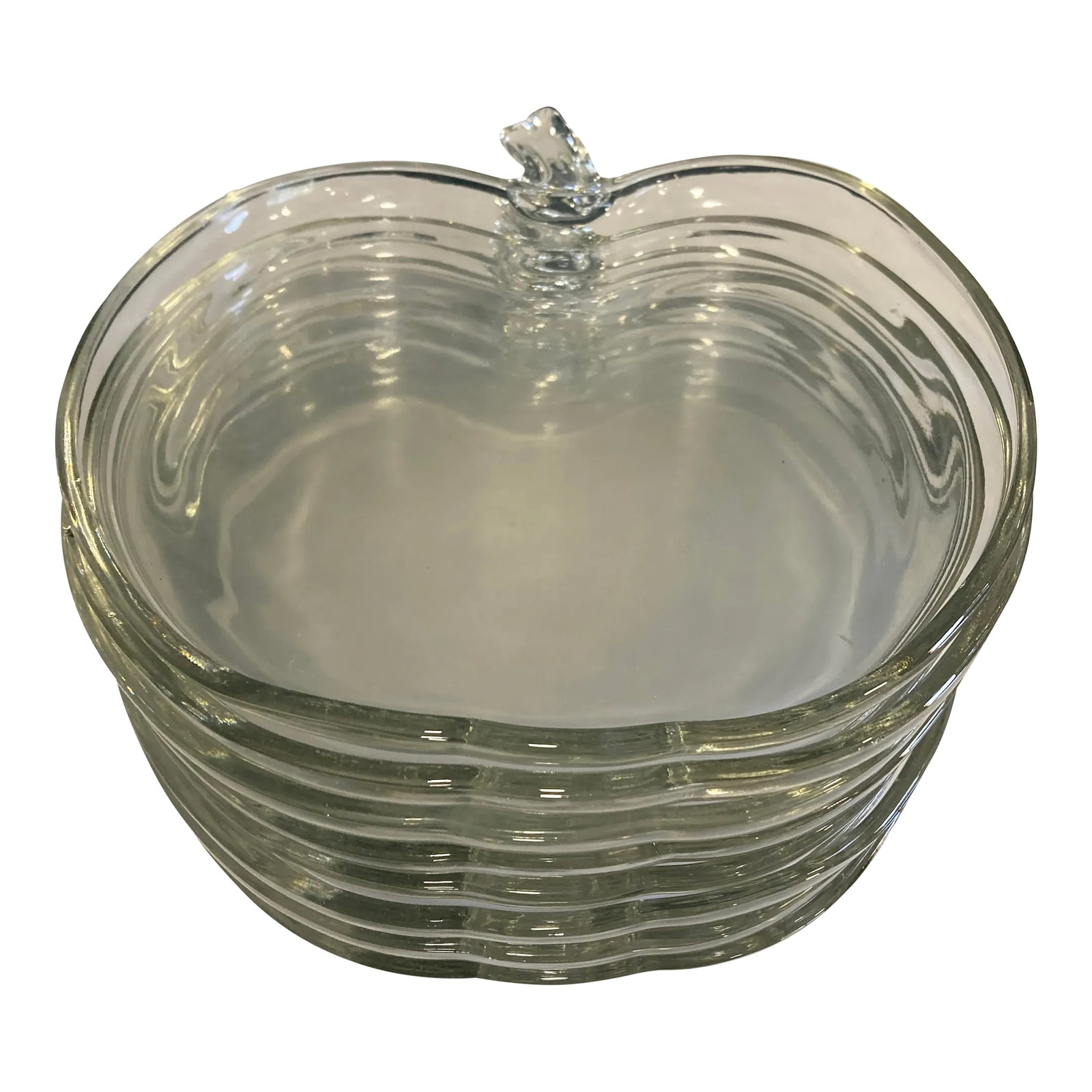 Mid 20th Century Clear Glass Apple Plates- Set of 8: A delightful set of eight mid-century clear pressed glass apple-shaped plates. The sculptural fruit silhouette and molded stem create a playful yet clean-lined aesthetic typical of 1960s-70s