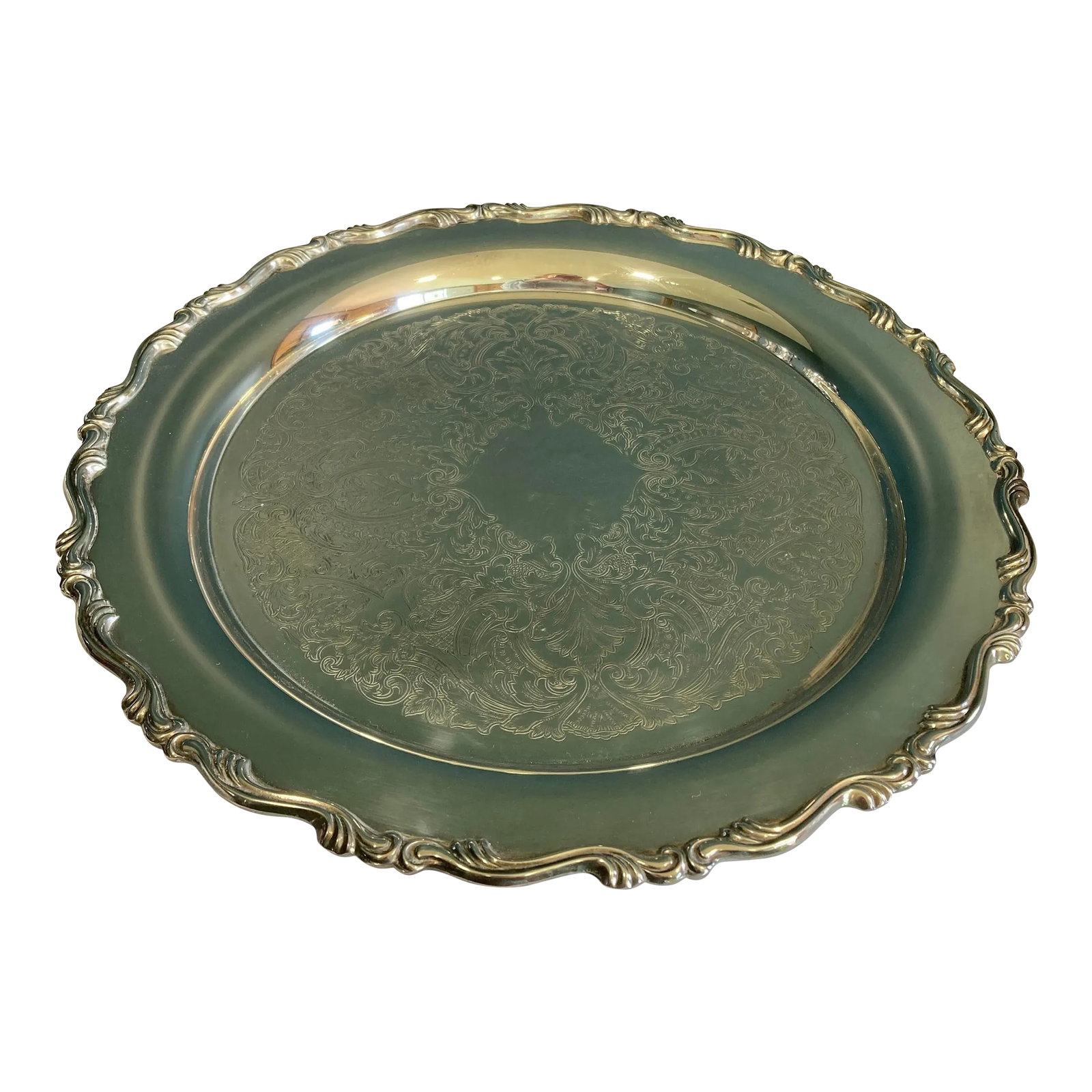 Vintage Oneida Silverplate Ornate Round Serving Tray: This vintage American silver plate tray by Oneida showcases timeless elegance with its ornate raised scroll border and delicately engraved interior. Made in the USA, it reflects quality craftsmanship