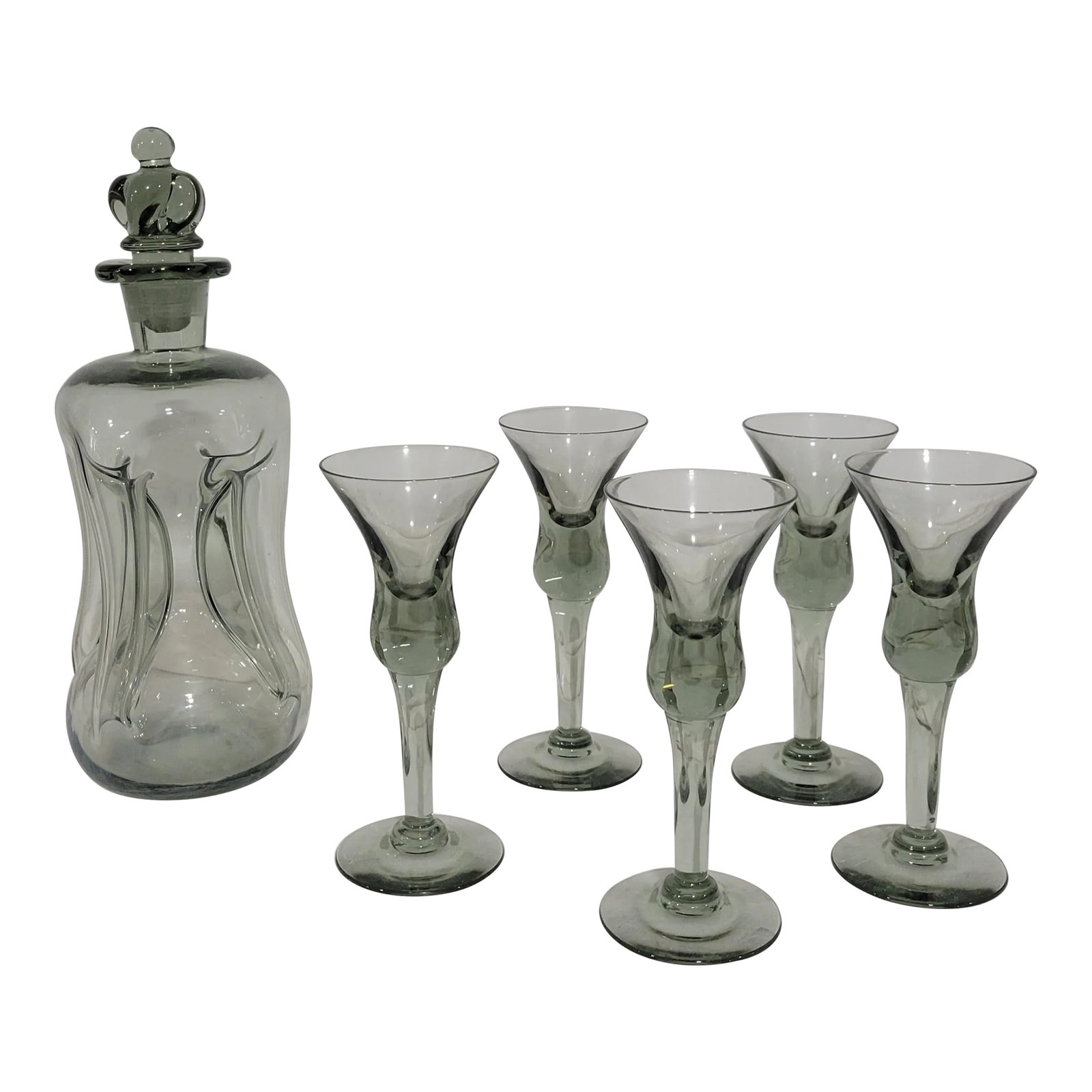 1950s Danish Modern Holmegaard Decanter and Glass Set- 6 Pieces: 1950s Holmegaard Decanter Set in Smoke Glass. The iconic "Cluck Cluck" decanter has the Crown ground Glass stopper variation. Set contains 1 decanter and 5 cordial glasses. As referenced on page 133