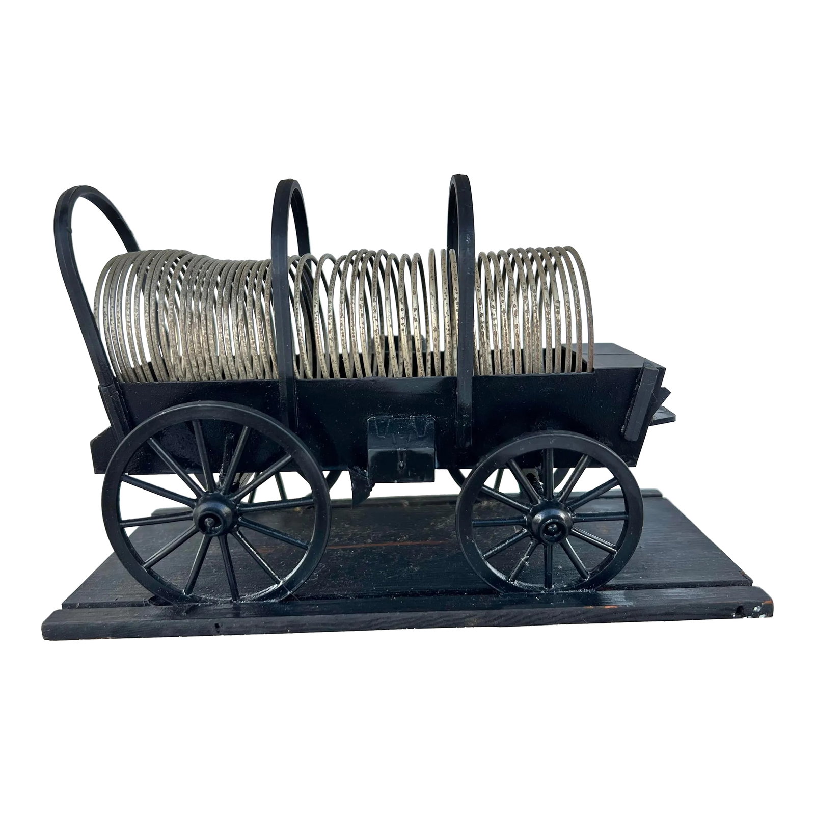 Mid Century Desk Accessory Chuck Wagon: Mid century model of a Western Chuck Wagon with a metal slinky inside. The "Chuck Wagon" desk decoration is a charming and unique addition to any office space. This piece serves as both a functional