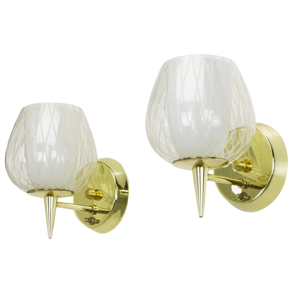 Gerald Thurston for Lightolier Etched Glass and Brass Sconces - a Pair: Pair of brass double hurricane sconces by Gerald Thurston for Lightolier. Each solid brass sconce has a double hurricane shade, with the inner shade being a milk glass cup, and the outer shade being a
