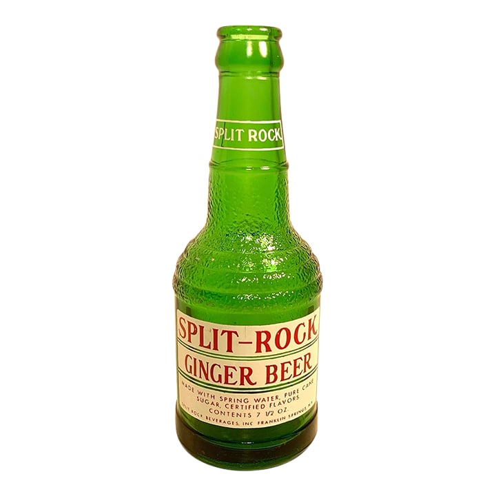 1960s Mid Century Split Rock Green Glass Ginger Beer Bottle: This is a circa 1960s Split Rock Beverages ginger beer bottle in textured green glass with its original applied paper label. The bottle has a distinctive hammered textured surface, embossed base