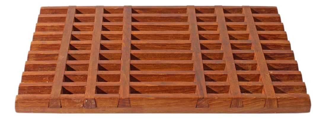 Jens Quistgaard Dansk Teak Lattice Trivet: A trivet designed by the Danish designer Jens Quistgaard (1919-2008) for Dansk International Designs. Made of teak wood, this trivet has a lattice pattern with intersecting lines. The underside of