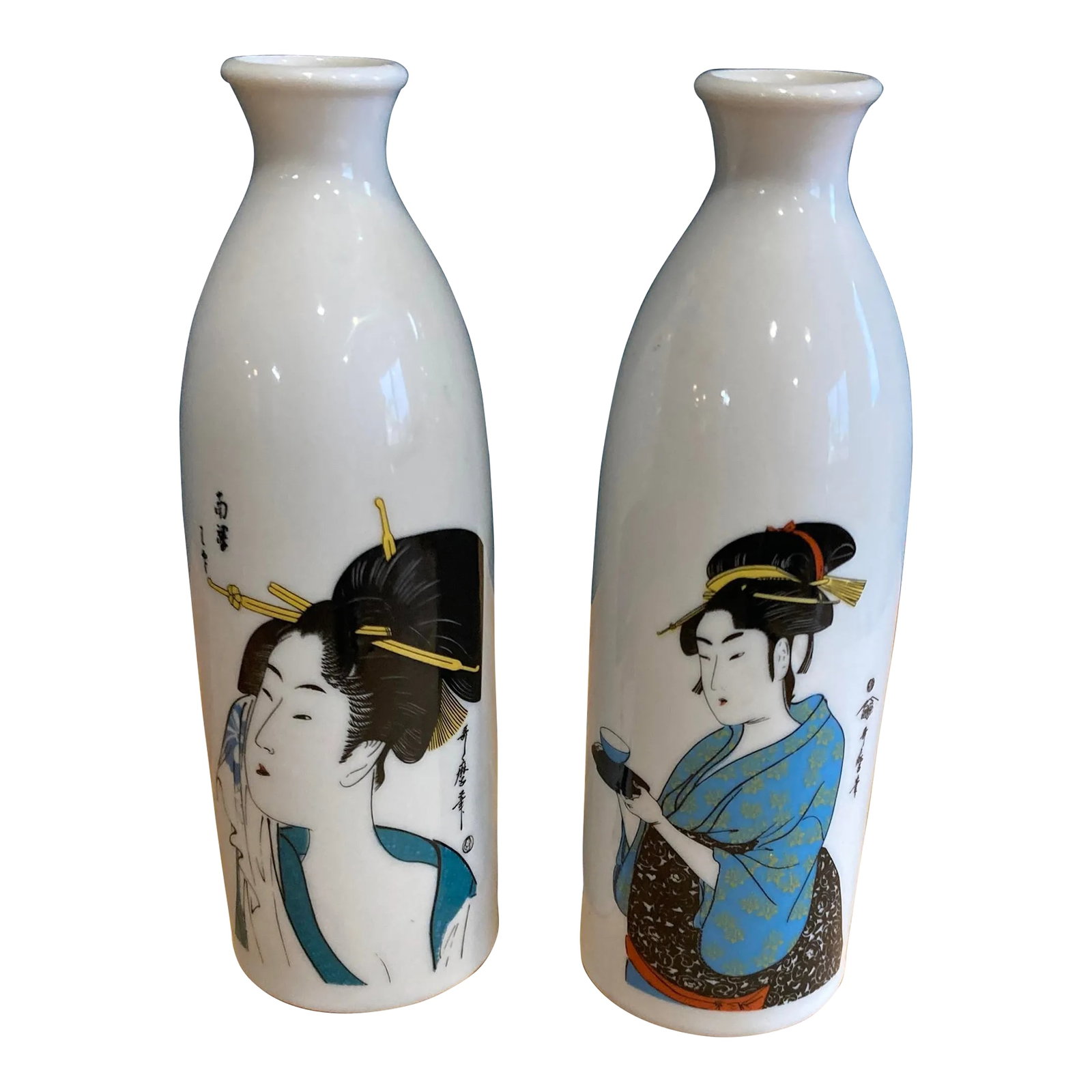 Vintage Pair of Japanese Porcelain Vases Featuring Geishas in Blue Kimonos: This lovely pair of Japanese porcelain vases features detailed depictions of geishas in traditional attire, rendered in vivid colors and fine linework. These tall, narrow vases (or sake bottles) offer