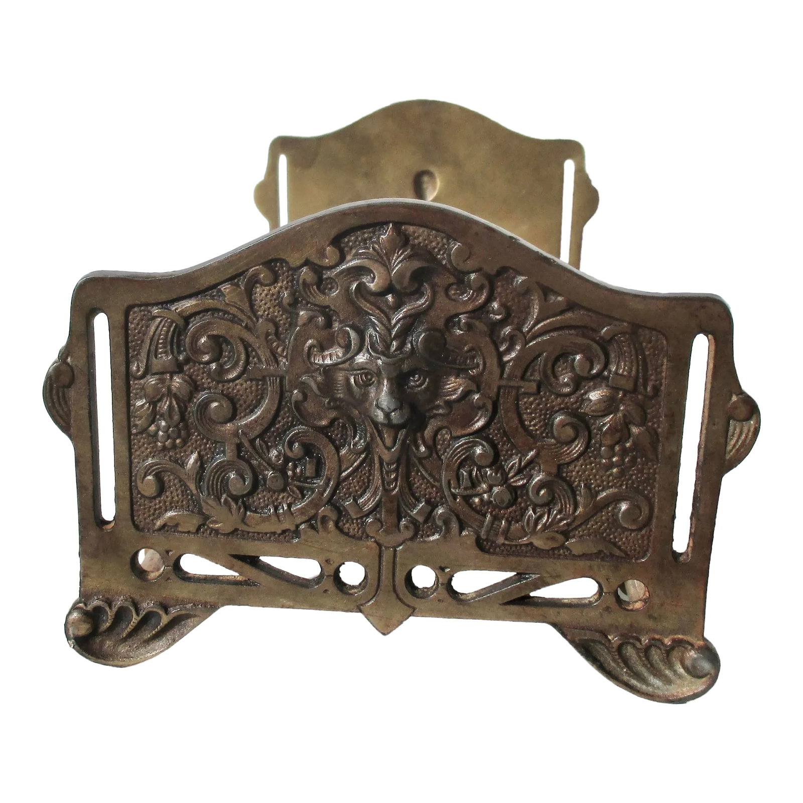 Edwardian Gothic Revival Expandable Book Holder Circa 1900: Edwardian brass-coated iron bookholder. Expandable design to hold sets of books upright on a table or desk. Revival Gothic lion face emerges among a scrolling pattern of lappets and flowers. Heavy cas