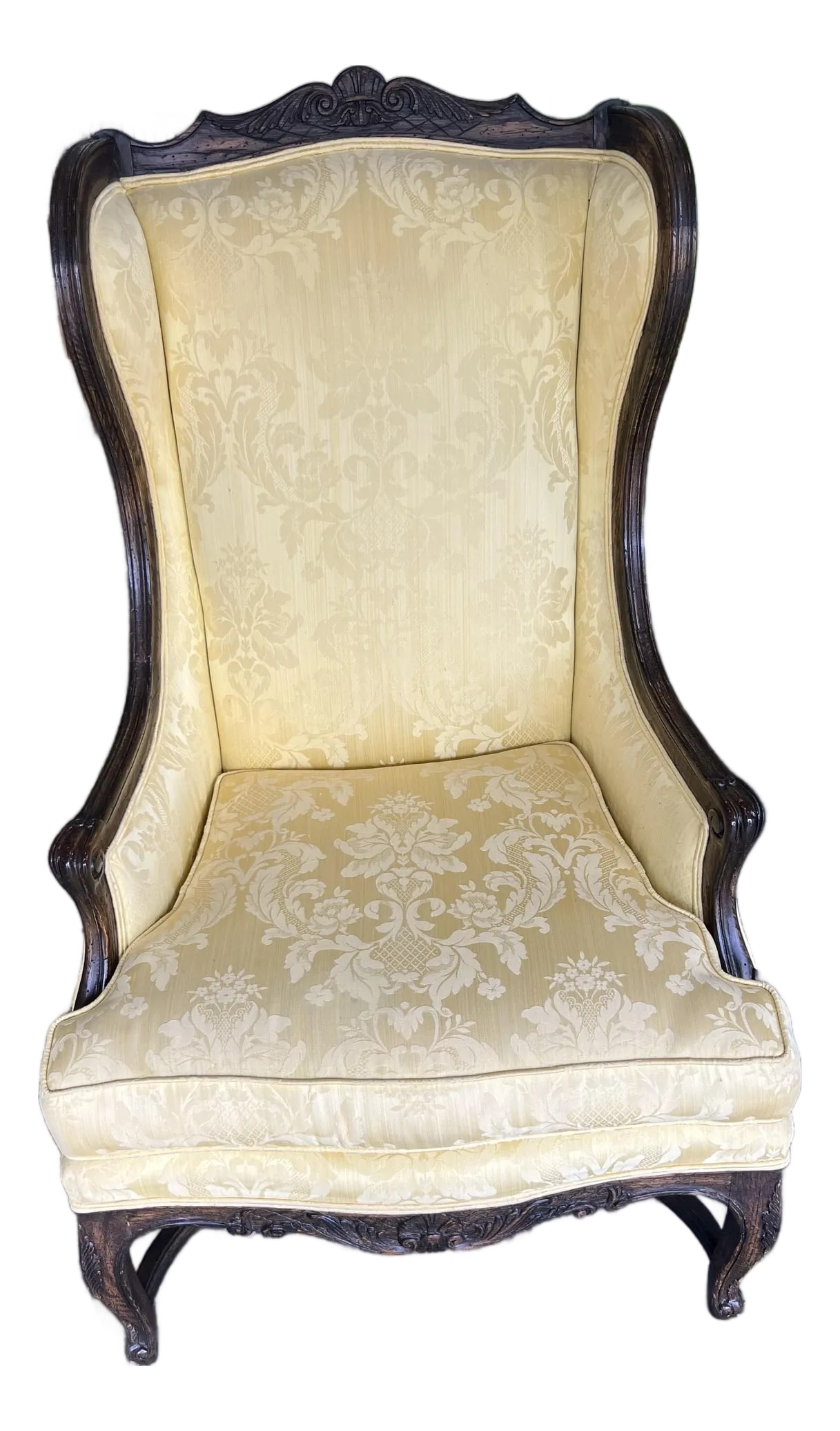 20'th C. Reproduction French Louis XV Revival Wing Chair: Antique French wingback chair upholstered in yellow silk damask. The frame is a dark-stained hardwood featuring a camel back crest rail with floral and foliate carving. Cabriole front legs and scrolli