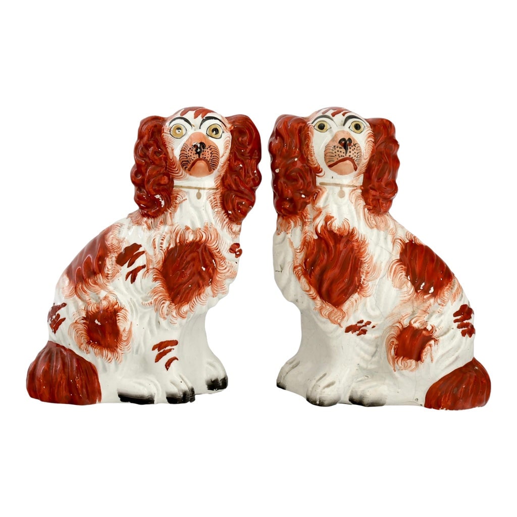 19th Century Staffordshire No. 4 Dogs / Spaniels: Mid 19th century Staffordshire pottery King Charles spaniel dogs modeled in the traditional seated form with expressive faces and hand-painted red and white decoration. Numbered "4" to the underside,