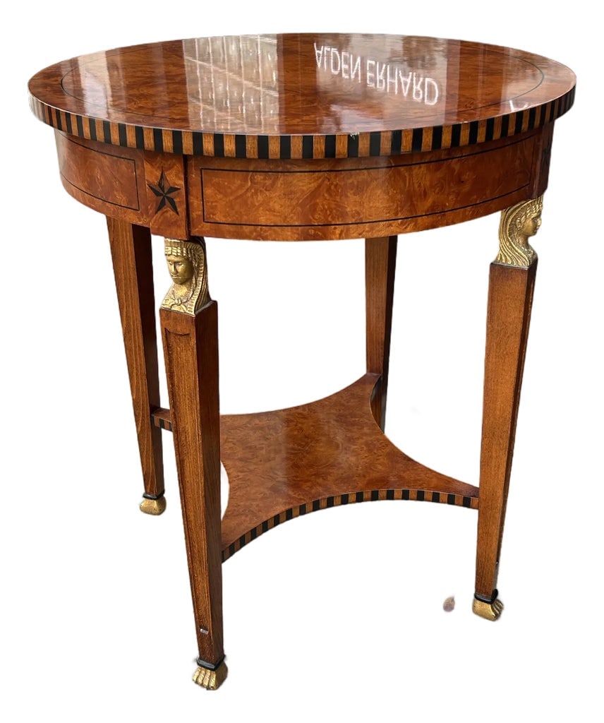 1960s Vintage French Empire Style Round Side Table: Handsome French Empire style side or occasional table crafted in walnut with a round burled top on four legs with carved and gilt heads, burled panels and gilt paw feet. Condition: Alterations: Origin