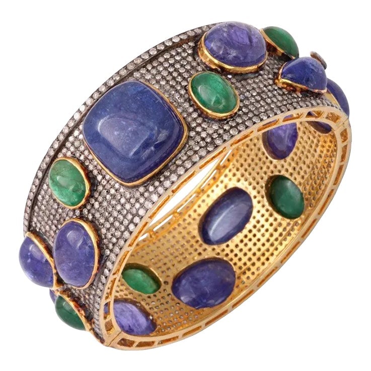 Bold Pave Diamond Bangle with Cabochon Tanzanites and Emeralds: This impressive bangle is beautifully made with over 12 carats of diamonds, over 18 carats in emeralds, and over 28 carats in tanzanites. Interior measures 2 3/8" by 2 1/16". The interior