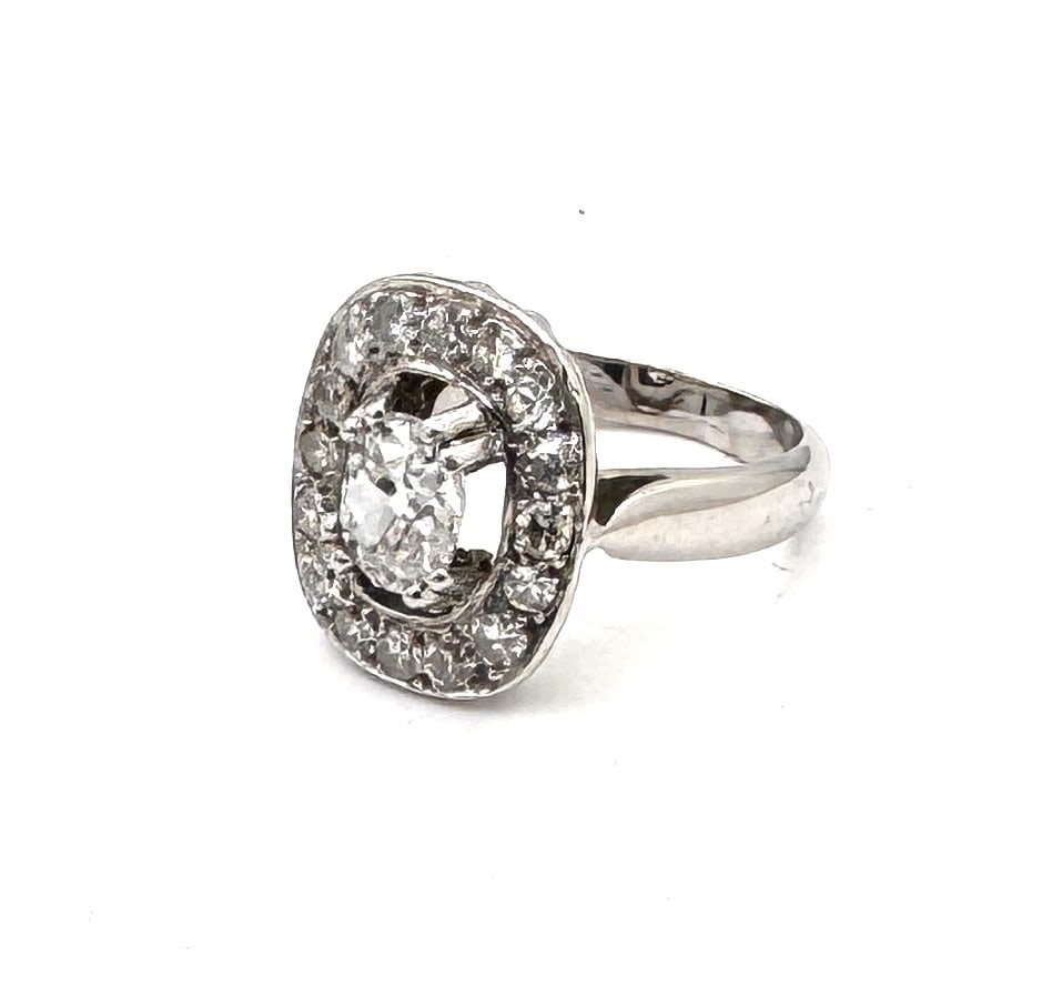 AN IMPRESSIVE ANTIQUE DIAMOND CLUSTER RING A magnificent "Belle Époque" inspired halo design in 18k: A superb and substantial antique-style cluster ring, masterfully crafted in 18k yellow and white gold (750/1000). This piece is centered upon a commanding round brilliant-cut diamond weighing approxim