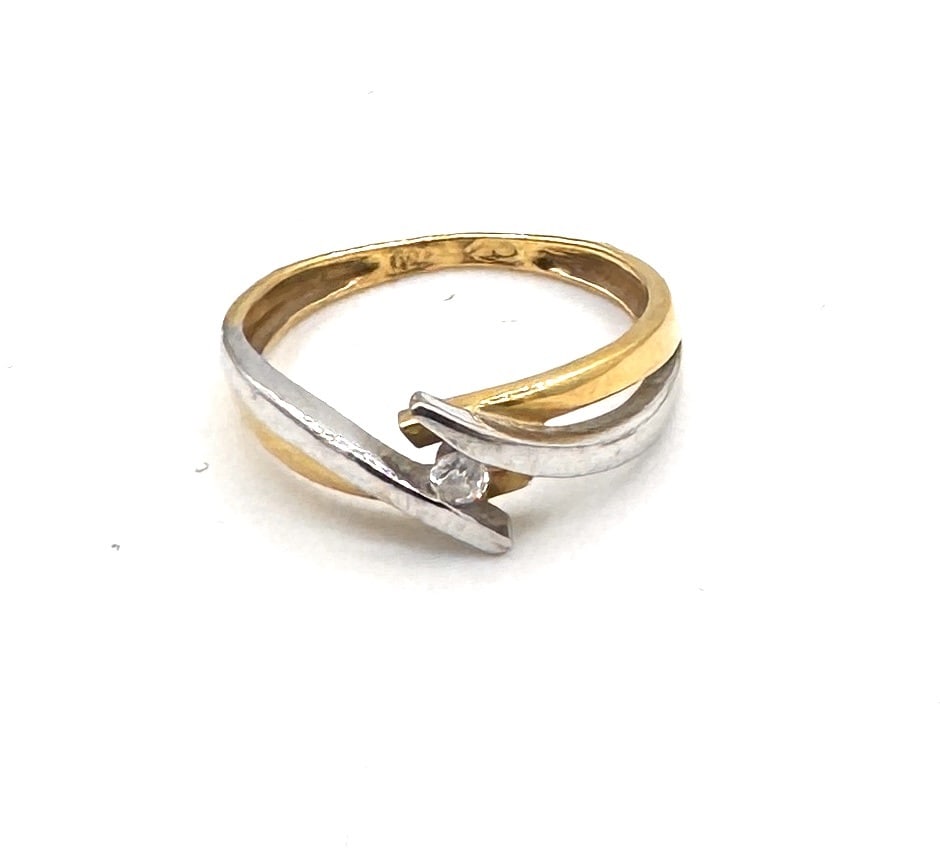 A DIAMOND SOLITAIRE RING A classic bicolor design in 18k gold: An elegant solitaire ring featuring a round brilliant-cut diamond weighing approximately 0.10 carat. The gemstone is securely held within a traditional six-prong illusion setting in white g