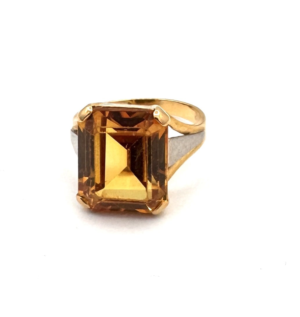 A VINTAGE CITRINE COCKTAIL RING A bold mid-century statement in 18k gold: A striking vintage cocktail ring of impressive proportions, masterfully crafted in 18k yellow gold (750/1000). The centerpiece is a magnificent emerald-cut citrine, measuring approximately