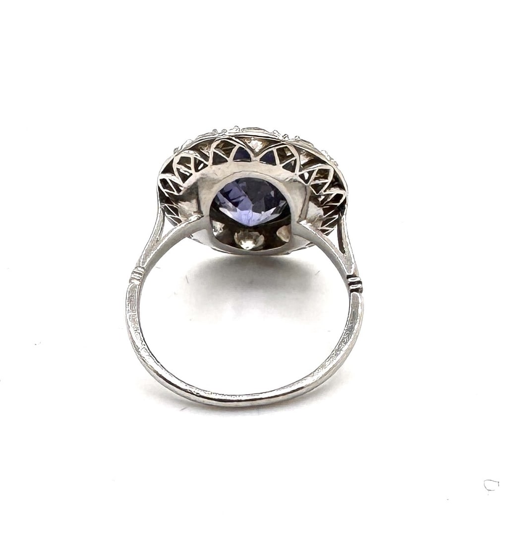 A FINE SAPPHIRE AND DIAMOND CLUSTER RING A classic "Royal" silhouette of exceptional proportions in: An elegant and high-impact sapphire dress ring, masterfully crafted in 18k yellow gold (750/1000). The design is centered upon a magnificent oval-cut blue sapphire, measuring approximately 13 x 9 mm. 