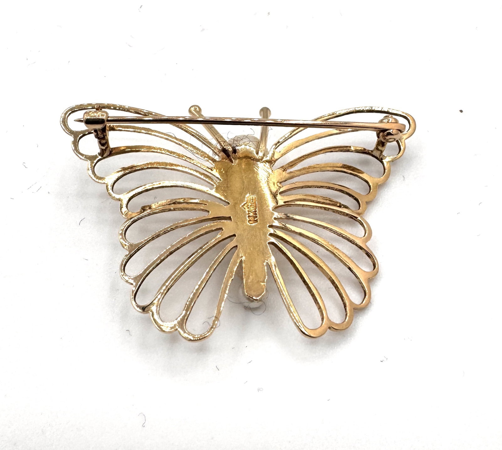 A VINTAGE PEARL AND GOLD BUTTERFLY BROOCH A finely detailed naturalist study in 14k gold: An exquisite vintage brooch designed as a butterfly in flight, showcasing masterfully textured 14k yellow gold (585/1000). The wings are characterized by an intricate openwork "filigree" pa