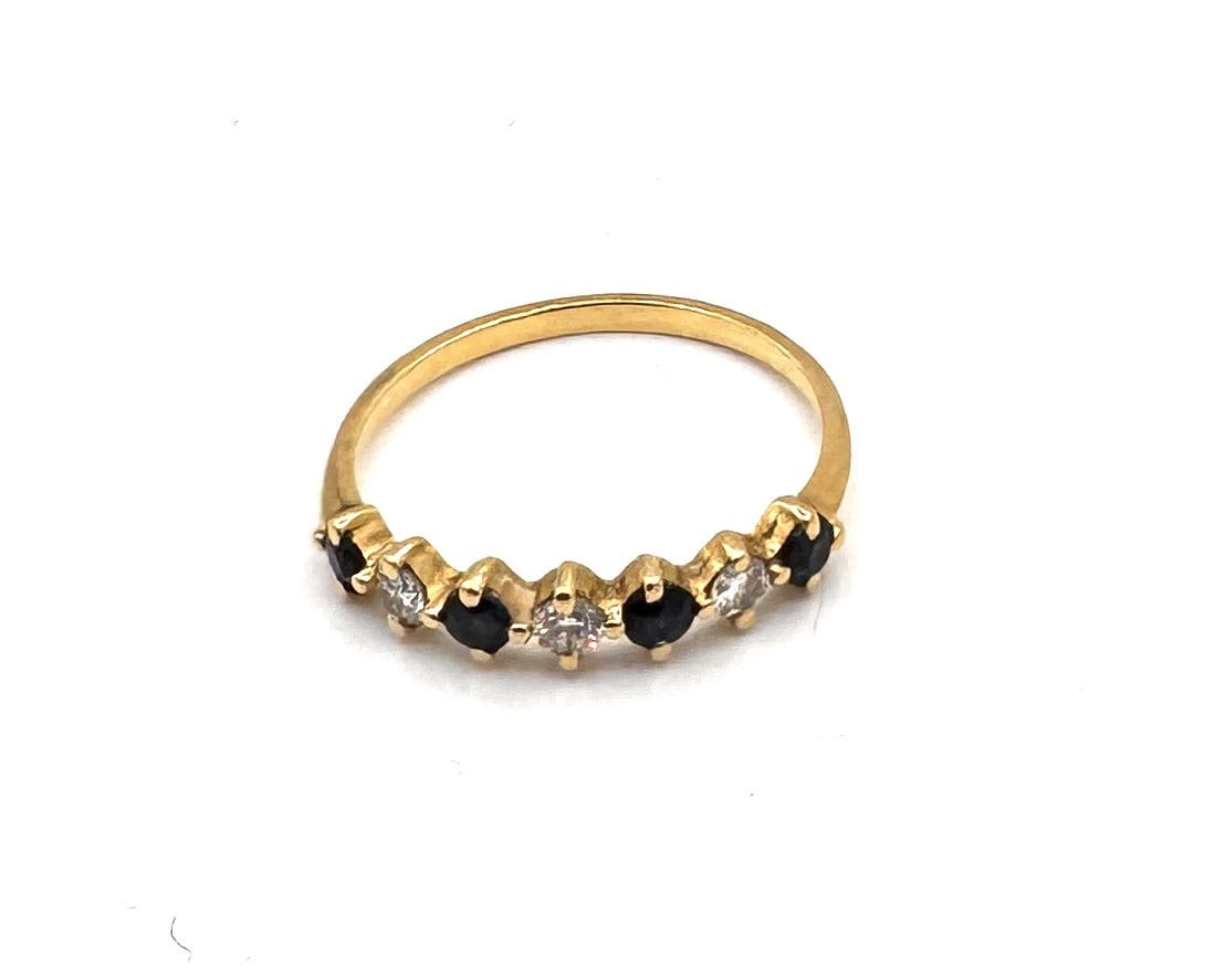 A SAPPHIRE AND DIAMOND HALF-ETERNITY RING Designed as a multi-stone band set in 18k yellow gold: An elegant half-eternity ring (alliance) featuring a rhythmic alternating sequence of round-cut sapphires and round brilliant-cut diamonds. Each of the seven gemstones is individually held within a de