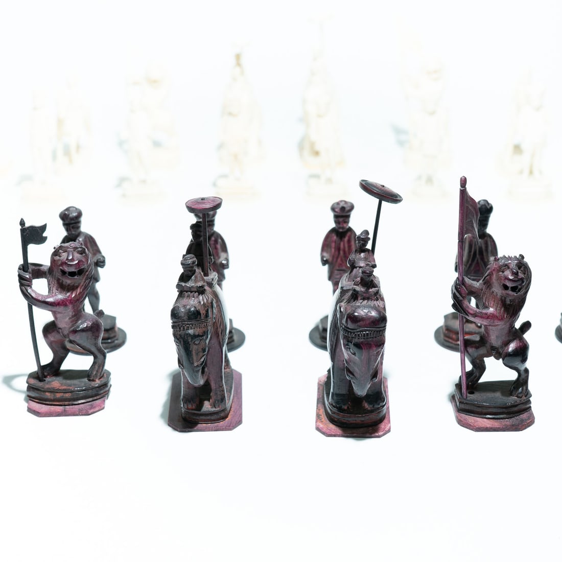 A late 18th century Indian central provincial ivory chess set: A late 18th l century Indian central provincial ivory chess set, one side stained purple, the bishop is portrayed as a standing lion holding a flag. The "John" Style: These are often referred to as "J