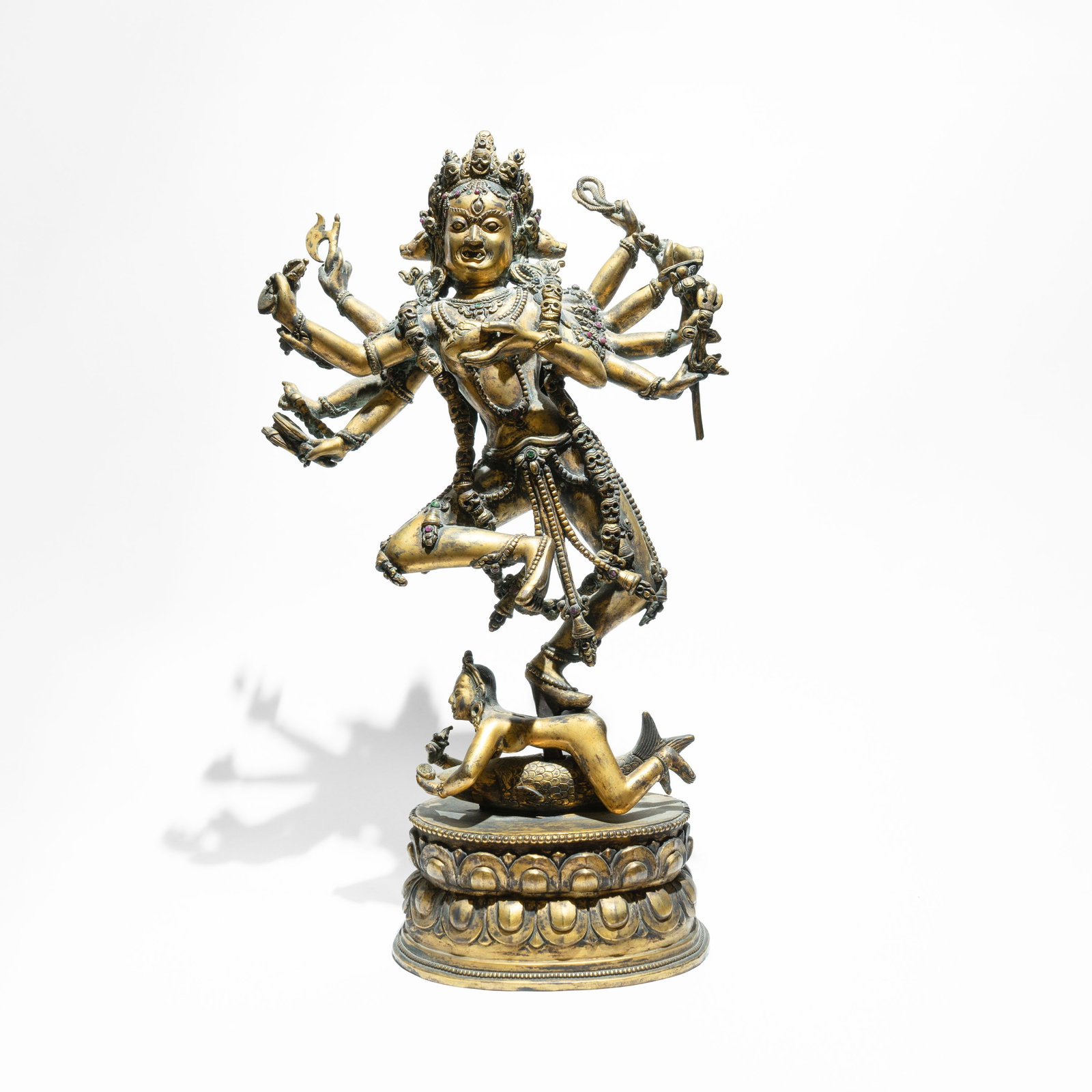 An Gilt-Bronze figure of Siddhi Lakshmi China/Tibet, Qianlong(1736-1795): Finely cast in the imperial style, the multi-armed deity is depicted in a dynamic alidhasana pose, balanced atop a prostrate figure on a double-lotus base. Her primary face displays a fierce yet seren