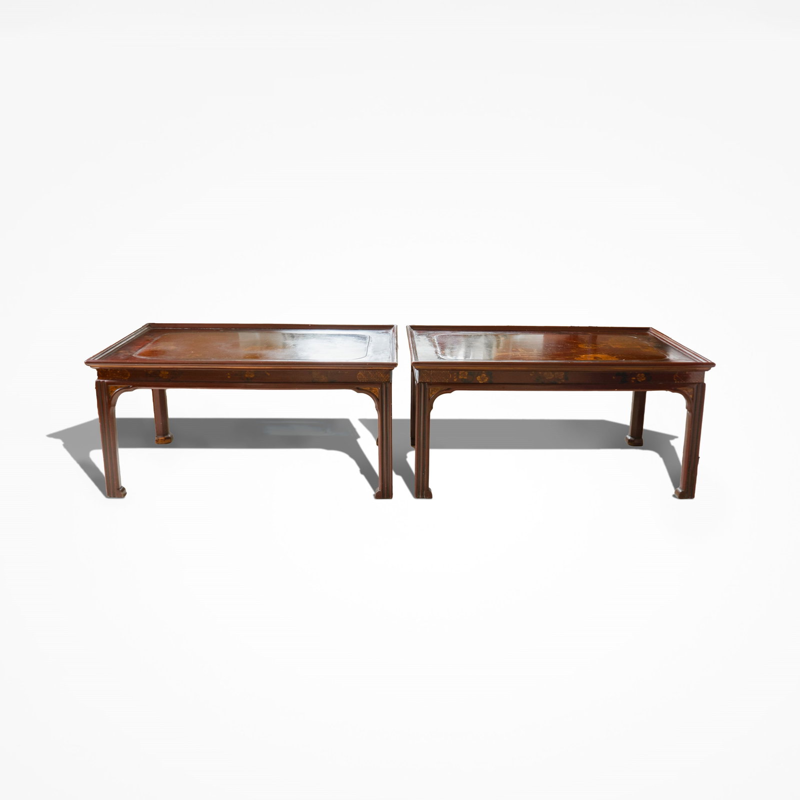 A Pair of Chinese Red Lacquer Wooden Chinoisserie Low Tables 19th Century: Featuring a rectangular top with rounded corners. The surface is wood coated with lacquer, intricately decorated in raised gilt (gold leaf). The gold-on-dark background style is characteristic of Chin