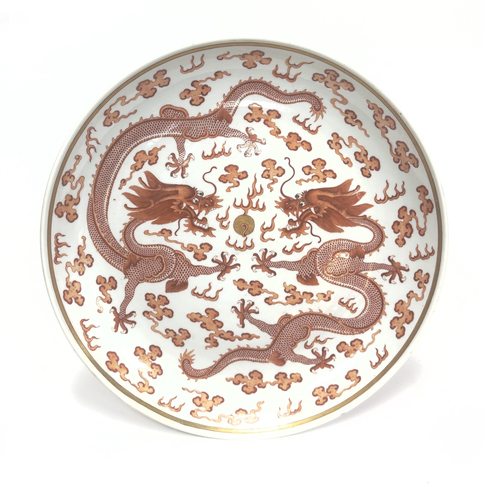 An Imperial Iron-red Decorated 'Dragon' Dish China, Qing Dynasty, Guangxu mark and period: The large dish is expertly painted in vivid iron-red enamels on a luminous white porcelain ground. The interior features a central medallion enclosing a powerful five-clawed dragon writhing amidst sty