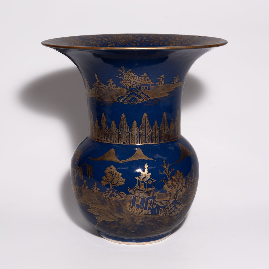 A Powder-Blue and Gilt-Decorated 'Landscape' Zhadou China, Qing Dynasty, 18th Century: A porcelain vessel of zhadou (leavings jar) form, characterized by a globular body tapering to a short foot and supporting a wide, trumpet-shaped flaring neck. The exterior is coated in a ric