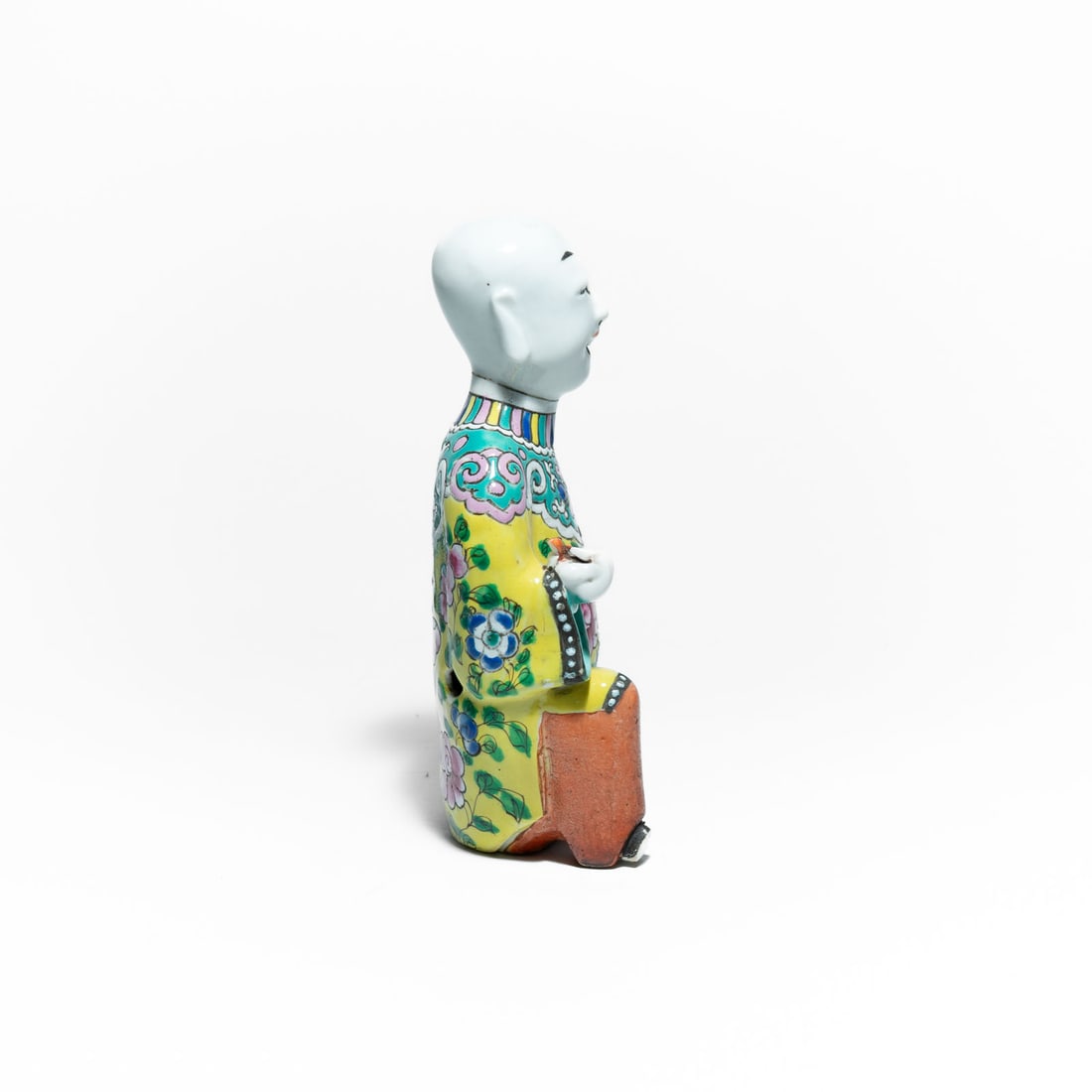 Laughing Boy (He-He Er Xian) in Chinese export porcelain Mid 19th Century: The boy is shown kneeling, typically holding a ruyi scepter in one hand (a symbol of good fortune and power) and sometimes a pomegranate in the other (symbolizing fertility and many offspring). It is 
