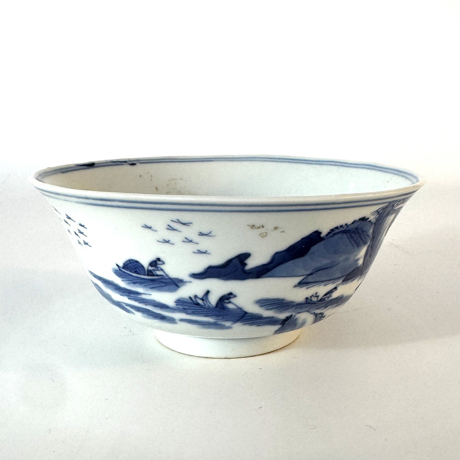 A blue and white porcelain 'Bleu de Hue' bowl China for the Vietnamese market, Qing Dynasty, 19th: The bowl is of deep circular form with flared sides rising from a short, straight footrim. It is finely painted in vibrant shades of underglaze cobalt blue with a continuous landscape scene depicting 
