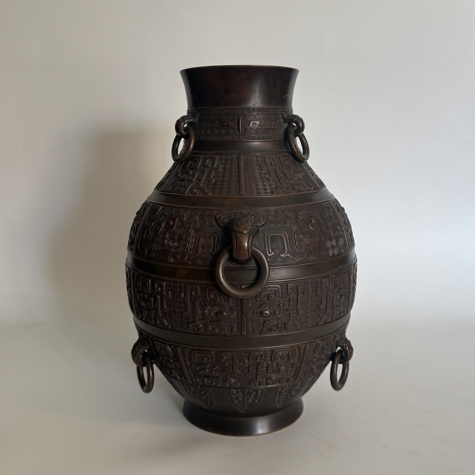 A Archaistic cast bronze and patinated "Hu" vase China, Qing Dynasty, Qianlong Period (1736–: An elegant and heavily cast bronze ritual vase, Hu, of pear-shaped form rising from a slightly splayed foot to a flaring neck.The exterior is meticulously cast in low relief with mul