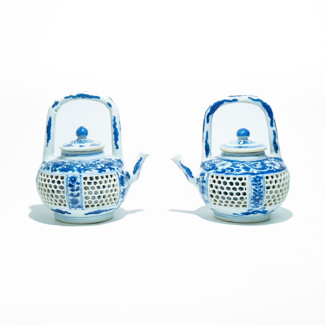Pair of Chinese export porcelain double-walled teapots with underglaze blue and white decoration.: These pieces showcase the intricate Linglong (reticulated or "devil's work") technique. The outer wall features a painstaking, hand-cut hexagonal honeycomb openwork pattern, while an solid inner wall 