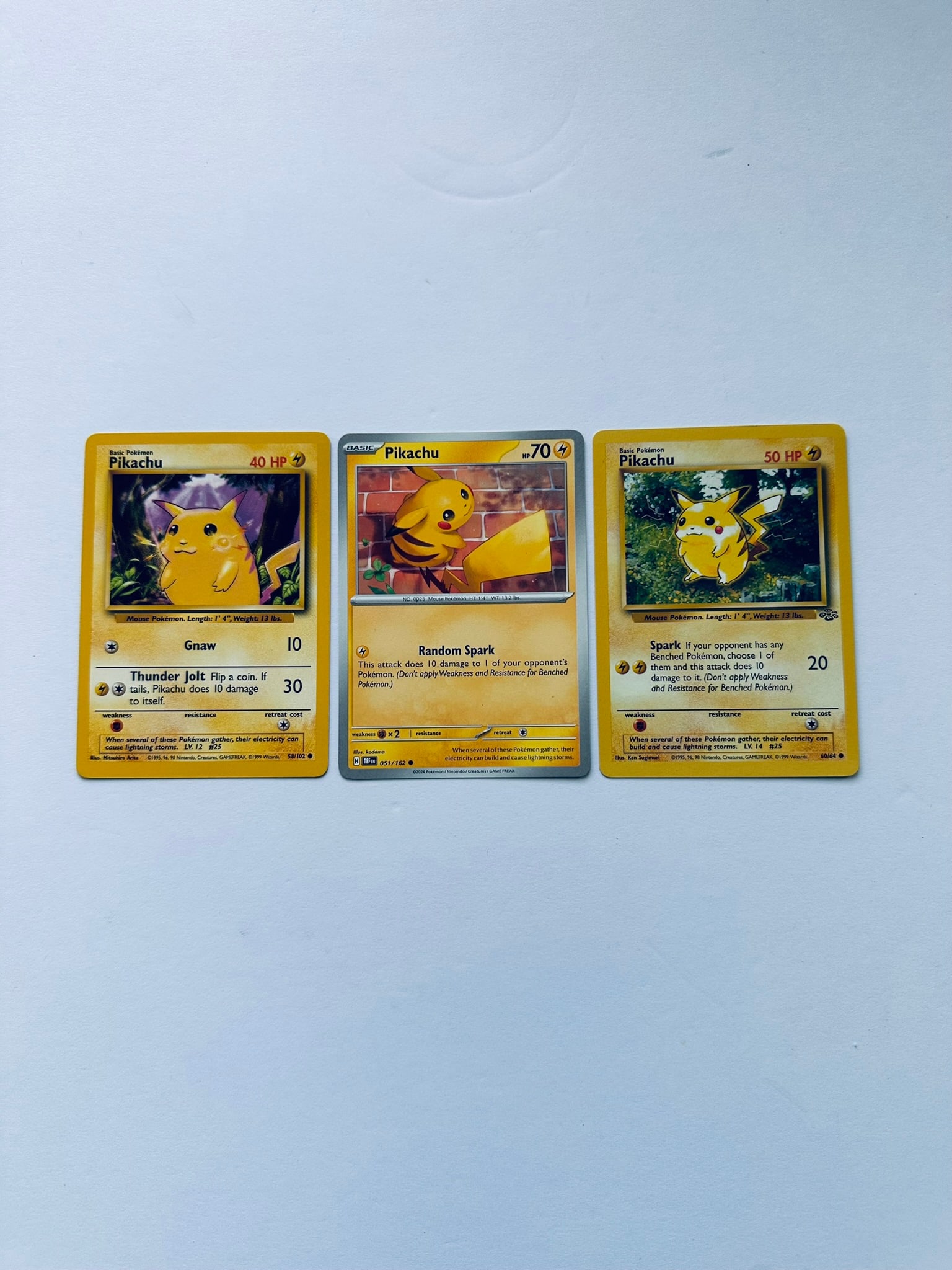 Pokemon Vintage Pikachu Lot (Base Set 58/102, XY Evolutions 60/108, BREAKthrough 51/162): Charming Pikachu collector lot featuring three cards from multiple eras of the Pokémon Trading Card Game. This lot includes the iconic Base Set Pikachu 58/102, Jungle Pikachu 60/64, and Pikachu 51/16