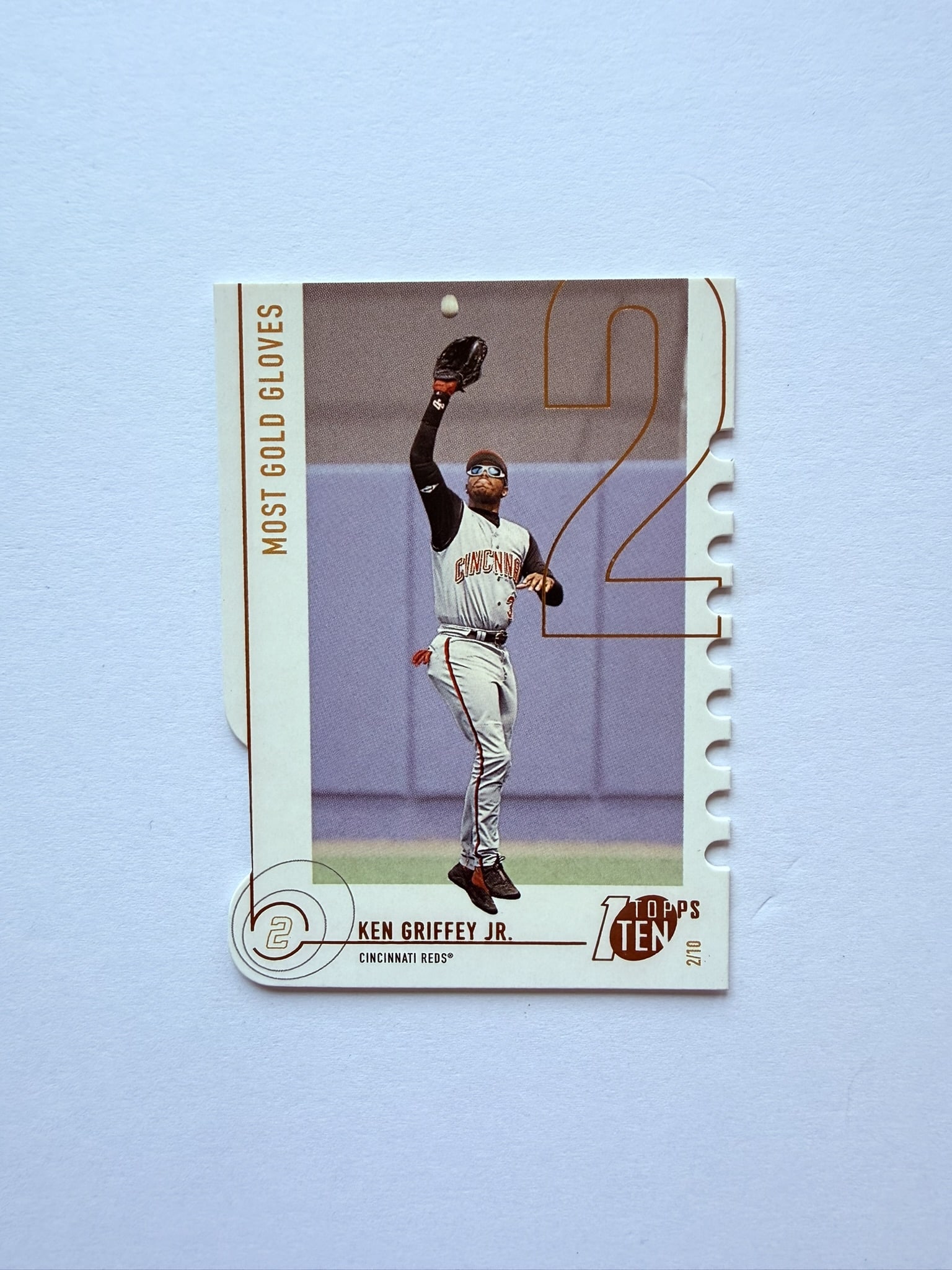 Ken Griffey Jr Topps Ten Most Gold Gloves Insert: Ken Griffey Jr. Topps Ten insert card highlighting Griffey’s Gold Glove achievements with the Cincinnati Reds. Unique die-cut edge design and collectible insert styling.