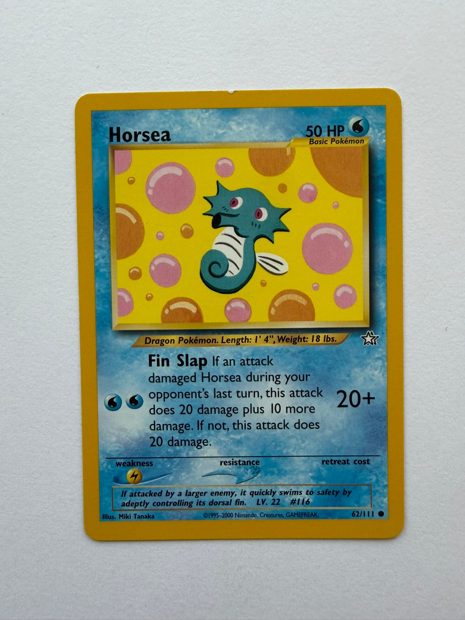 2000 Pokemon Horsea 62/111 Neo Genesis: Vintage Horsea 62/111 from the 2000 Neo Genesis expansion. Unlimited common card featuring colorful Miki Tanaka artwork. Ungraded with visible edge and surface wear. Please review photographs for cond