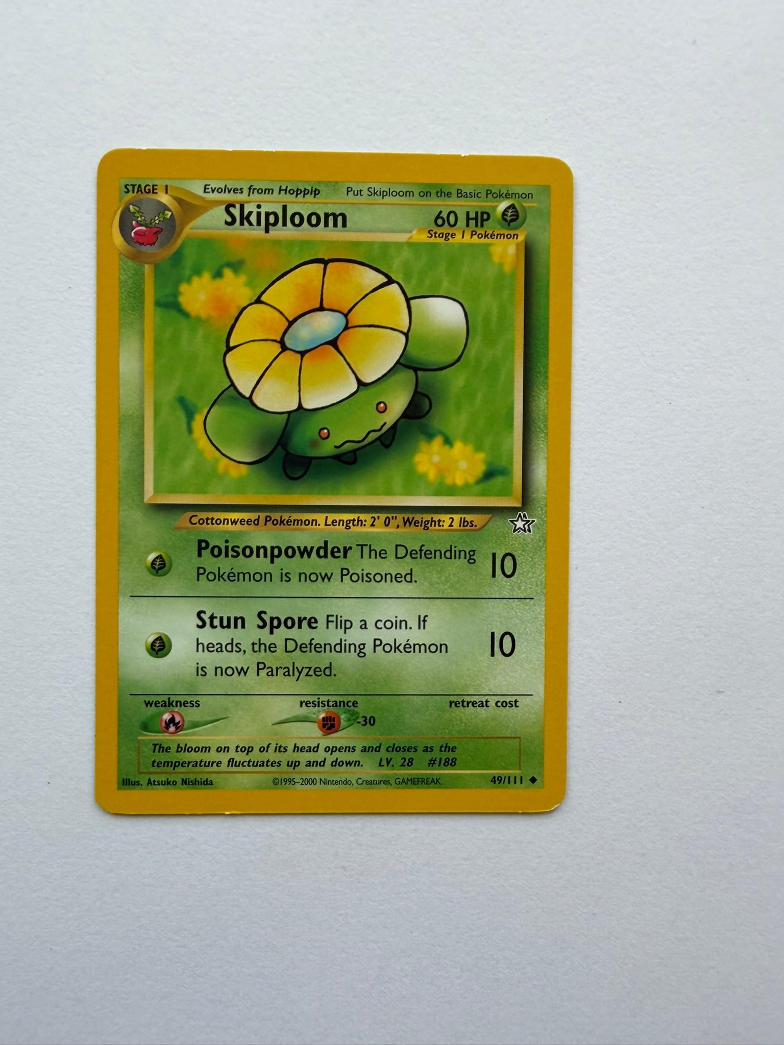 2000 Pokemon Skiploom 49/111 Neo Genesis: Vintage Skiploom 49/111 from the 2000 Neo Genesis expansion. Unlimited non-holo card featuring Atsuko Nishida artwork. Ungraded with visible age-related edge and surface wear.