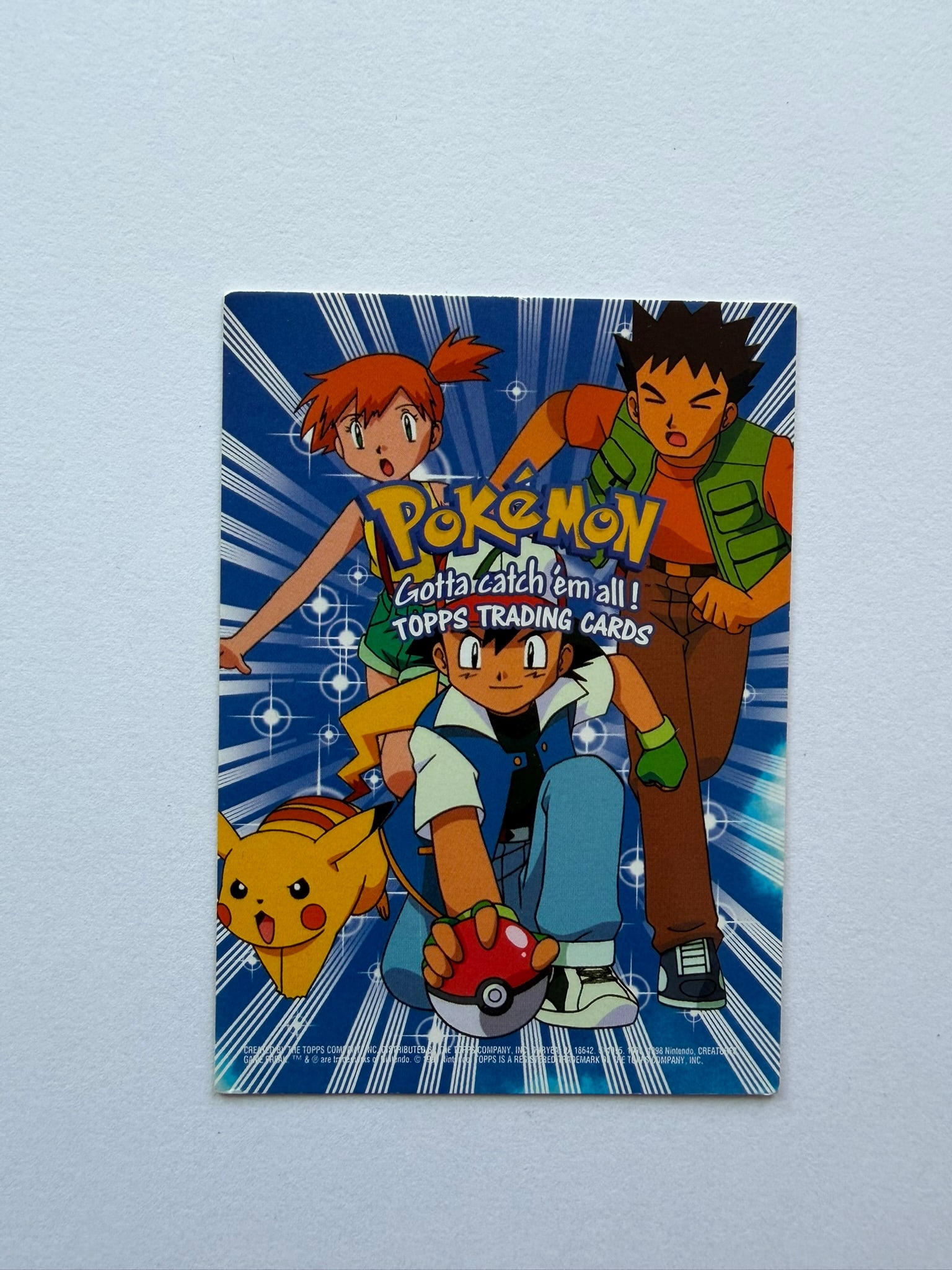 1999 Pokemon Topps Movie Animation Edition Checklist: Vintage Pokemon Topps Trading Cards checklist from the Movie Animation Edition. Features Ash, Misty, Brock and Pikachu with Gotta Catch 'Em All branding. Ungraded with visible edge, corner and surface